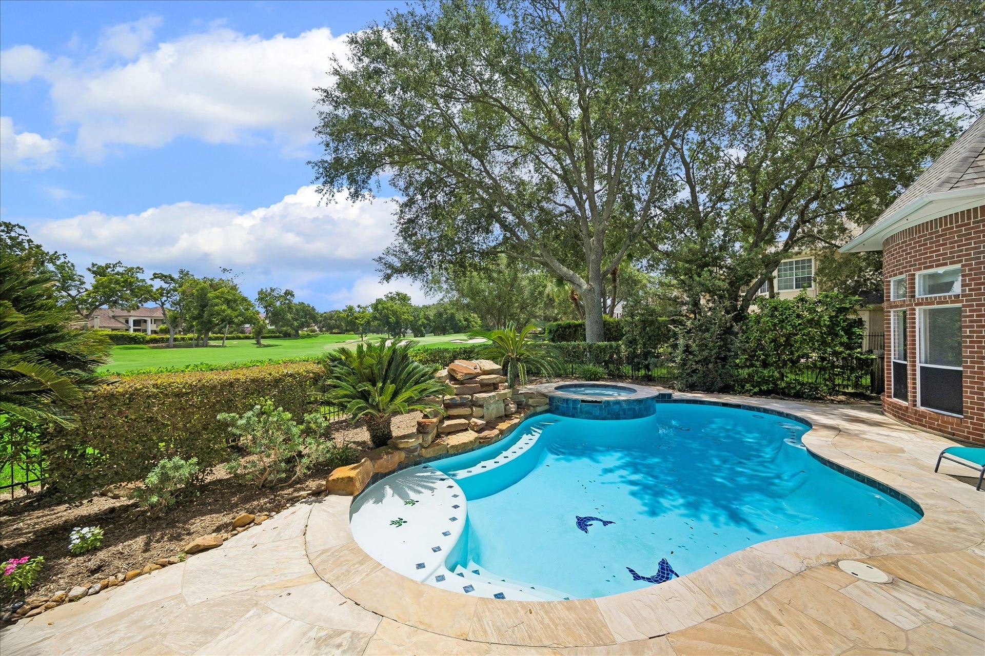 3319 Oakland Drive, Sugar Land, TX 77479 Outside, your private resort awaits: a covered balcony and flagstone patio frame a sparkling pool and spa, all overlooking the 14th hole of the Cypress course.