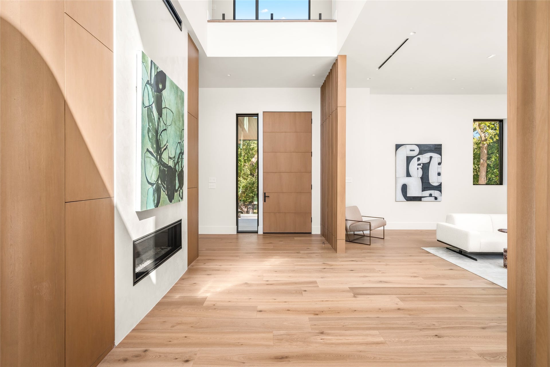 11 Tiel Way, Houston, TX 77019 The home's entry is defined by soaring ceilings, abundant natural light, and refined architectural details, with a custom wood entry door, white oak flooring, and thoughtfully integrated millwork creating a warm yet sophisticated welcome.