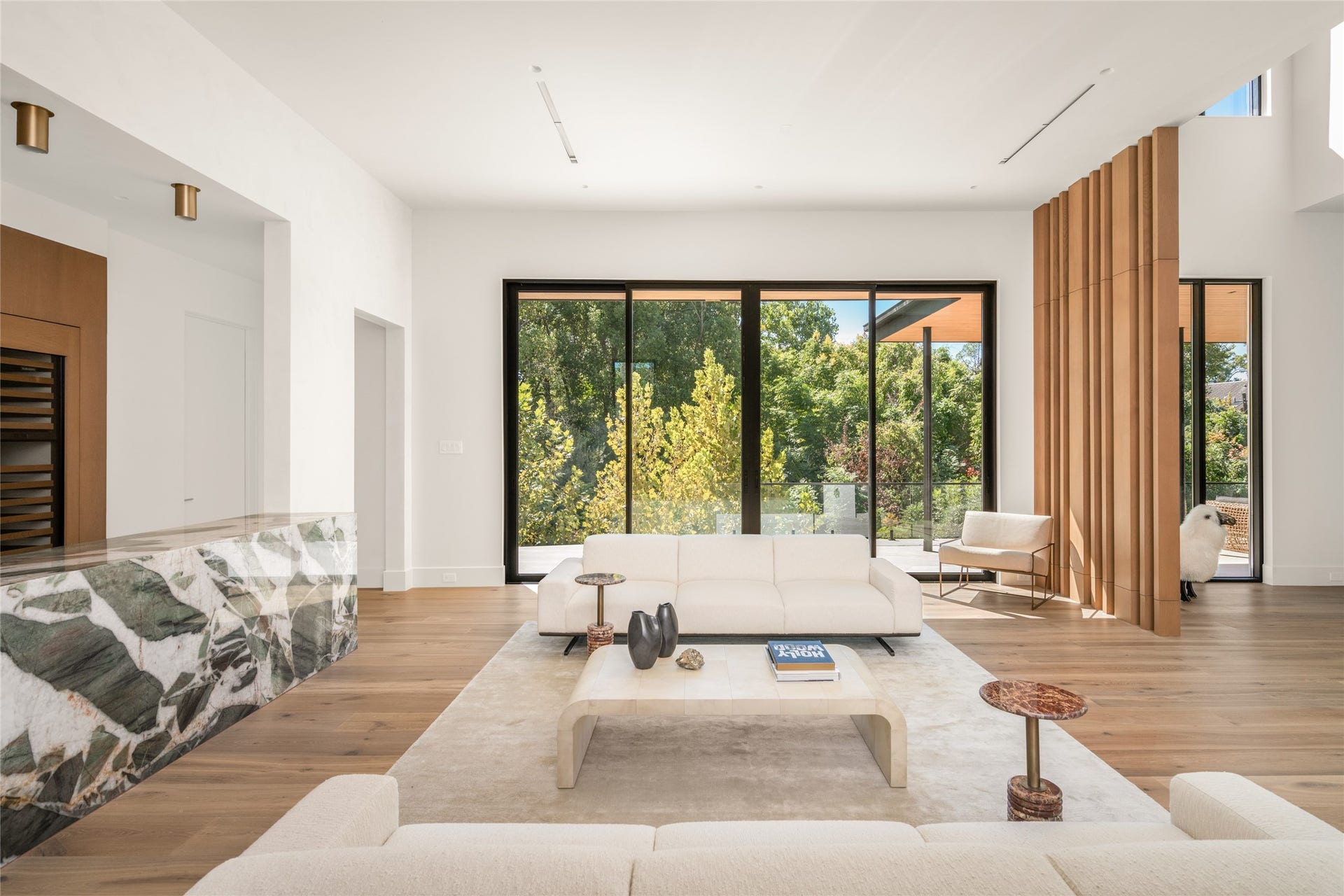 11 Tiel Way, Houston, TX 77019 Back inside, the bar opens to an expansive gathering space with floor-to-ceiling glass, a private terrace, and beautiful treetop views, creating a seamless connection between indoor and outdoor living.