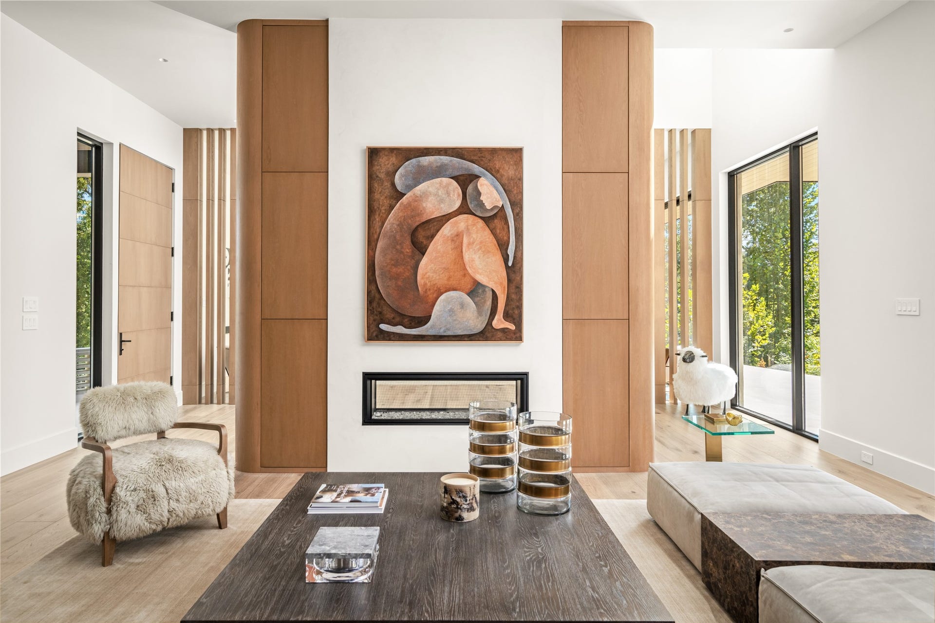 11 Tiel Way, Houston, TX 77019 A closer look at the family room reveals the beautiful symmetry of the double-sided fireplace, framed by softly curved white oak millwork, with architectural openings on either side that offer glimpses into the adjoining spaces.
