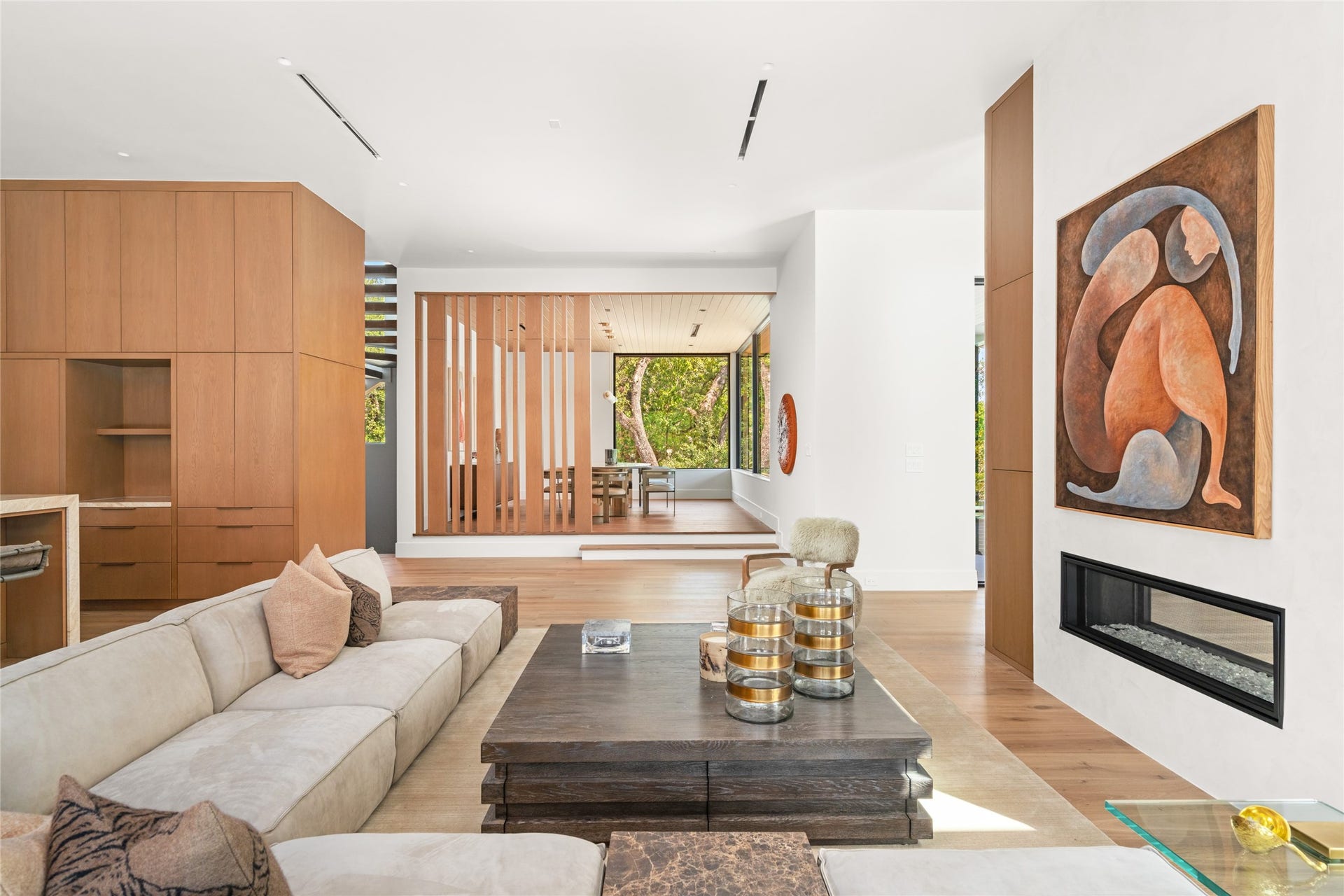 11 Tiel Way, Houston, TX 77019 The family room transitions beautifully into the elevated dining room, where a double-sided fireplace, custom white oak detailing, and thoughtfully designed architectural elements create a warm and inviting setting for entertaining.