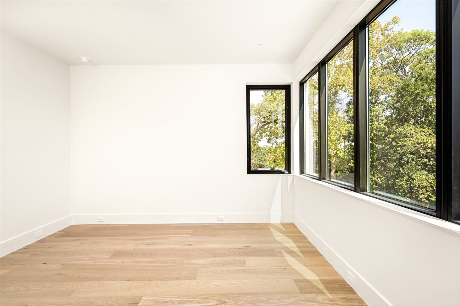 11 Tiel Way, Houston, TX 77019 A striking wall of expansive windows defines this spacious, light-filled bedroom suite, bringing the outdoors in and creating a beautiful connection to the surrounding landscape.