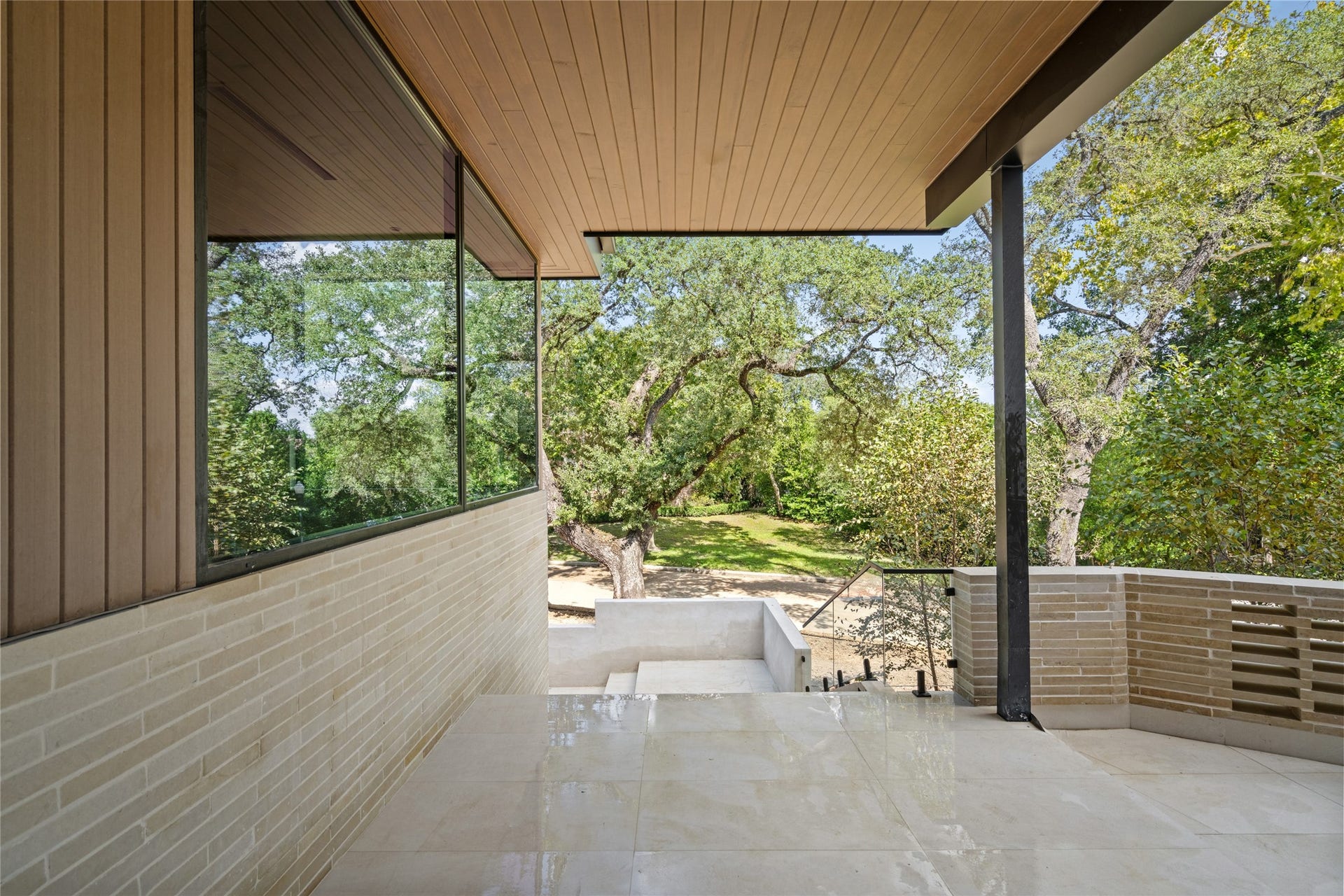 11 Tiel Way, Houston, TX 77019 A welcoming covered entry features warm wood ceilings, natural stone flooring, and clean architectural lines, offering a beautiful transition from the outdoors into the home.