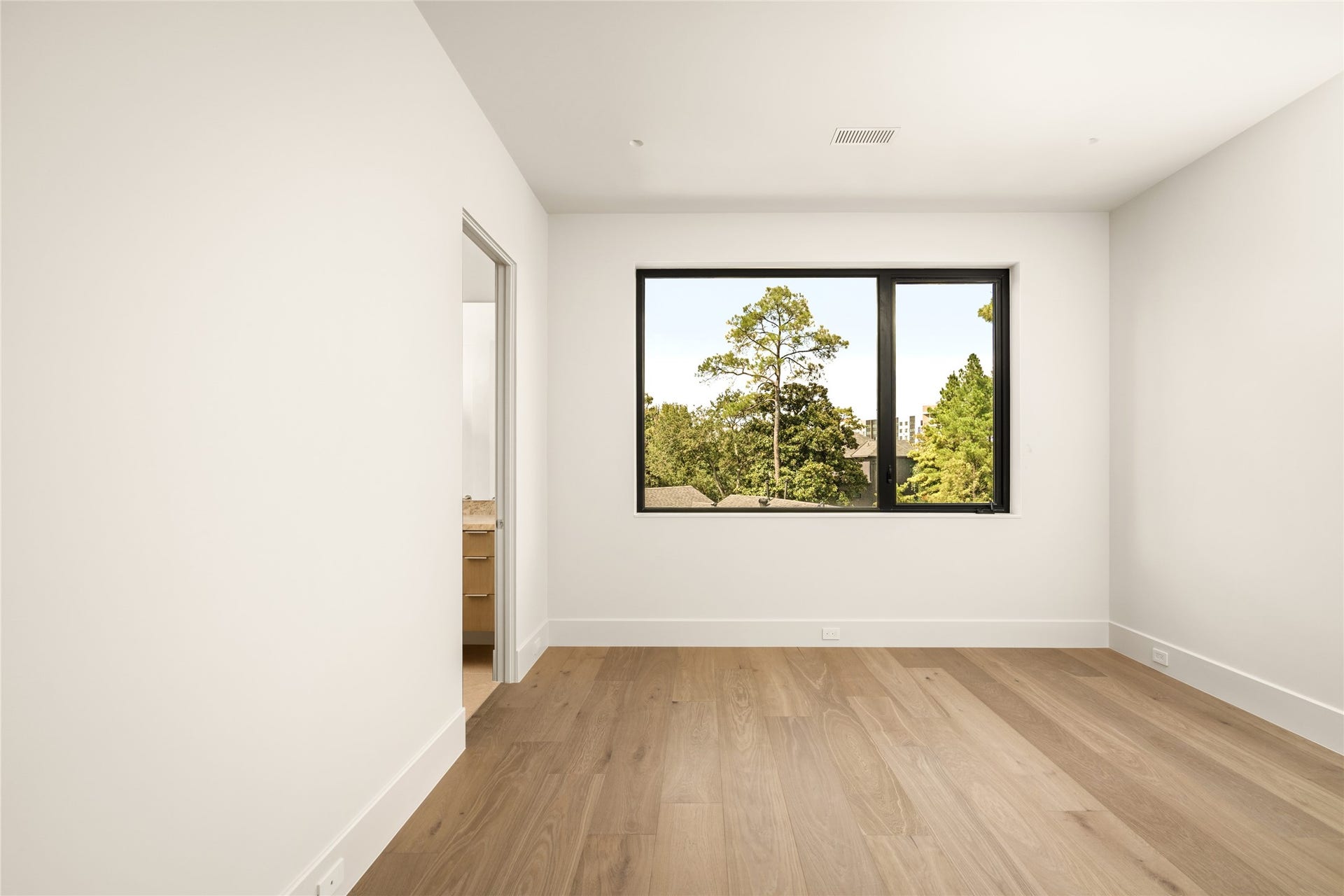 11 Tiel Way, Houston, TX 77019 This oversized 16' x 13' bedroom suite is a bright and inviting retreat with beautiful wood floors, a clean, contemporary aesthetic, and a picturesque window overlooking mature trees.