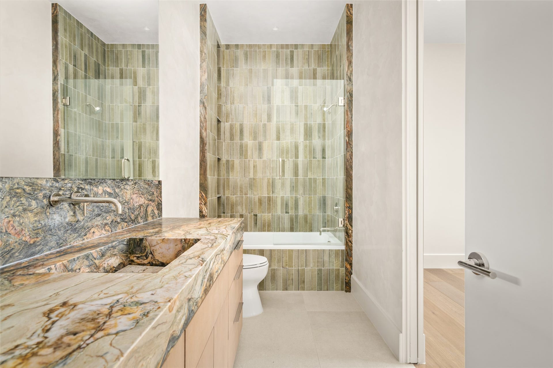 11 Tiel Way, Houston, TX 77019 A stunning Fusion quartzite vanity with an integrated sink takes center stage in this elegant ensuite bath, complemented by a spacious glass-enclosed shower and beautifully coordinated stone finishes.