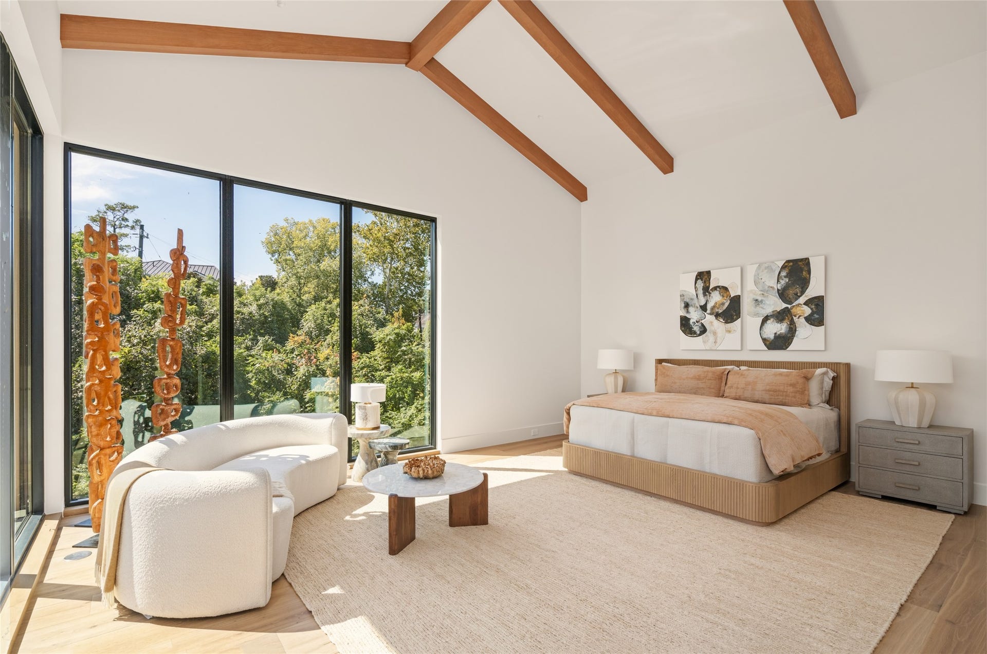 11 Tiel Way, Houston, TX 77019 The primary suite is a peaceful retreat, featuring a dramatic 20-foot vaulted ceiling with exposed wood beams and walls of glass that bring in natural light and frame the surrounding treetops.