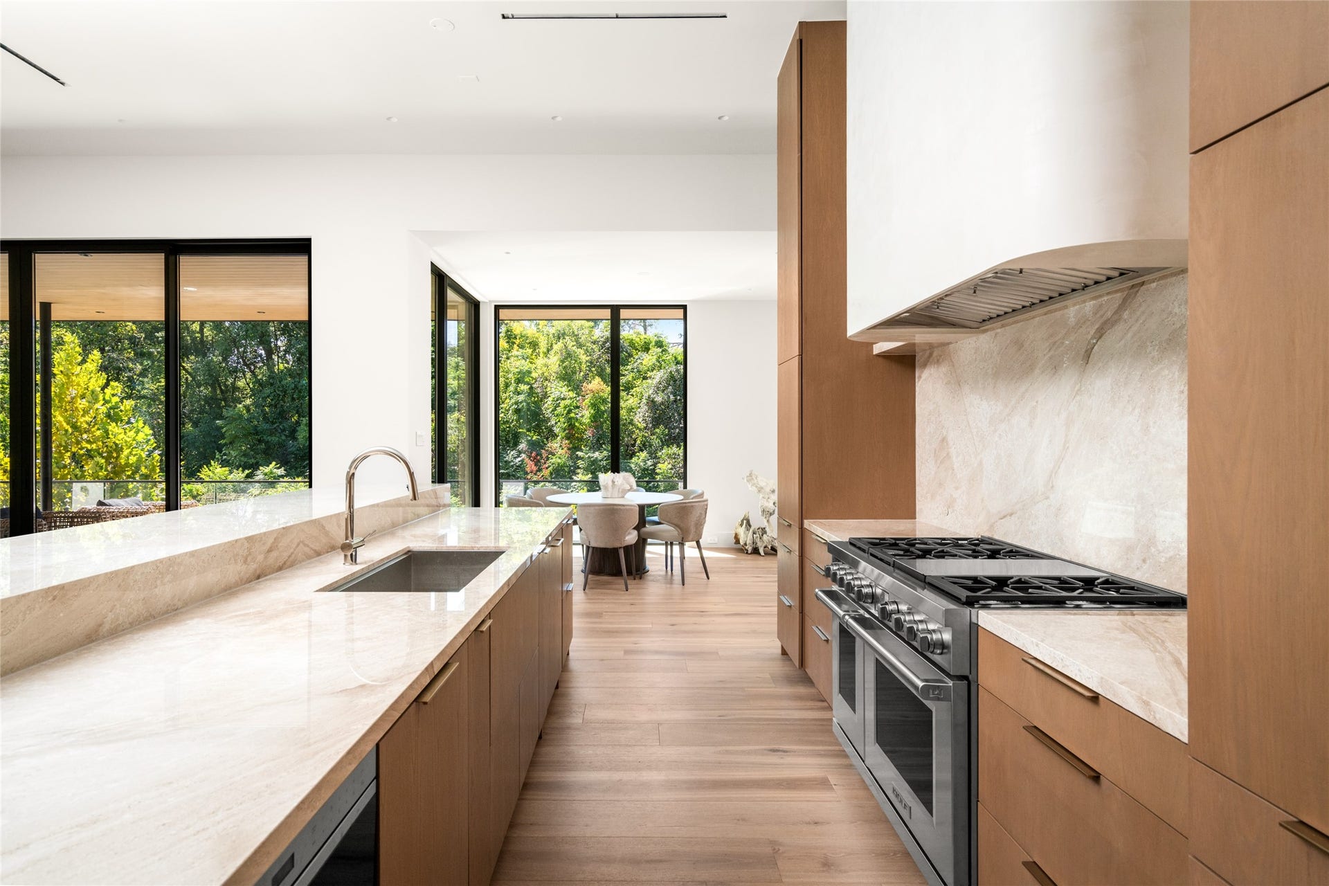 11 Tiel Way, Houston, TX 77019 A closer look at the chef's kitchen highlights the 48-inch Wolf dual-fuel range, full-height Daino Reale marble backsplash, and generous island preparation space, with the sunlit breakfast room just beyond.