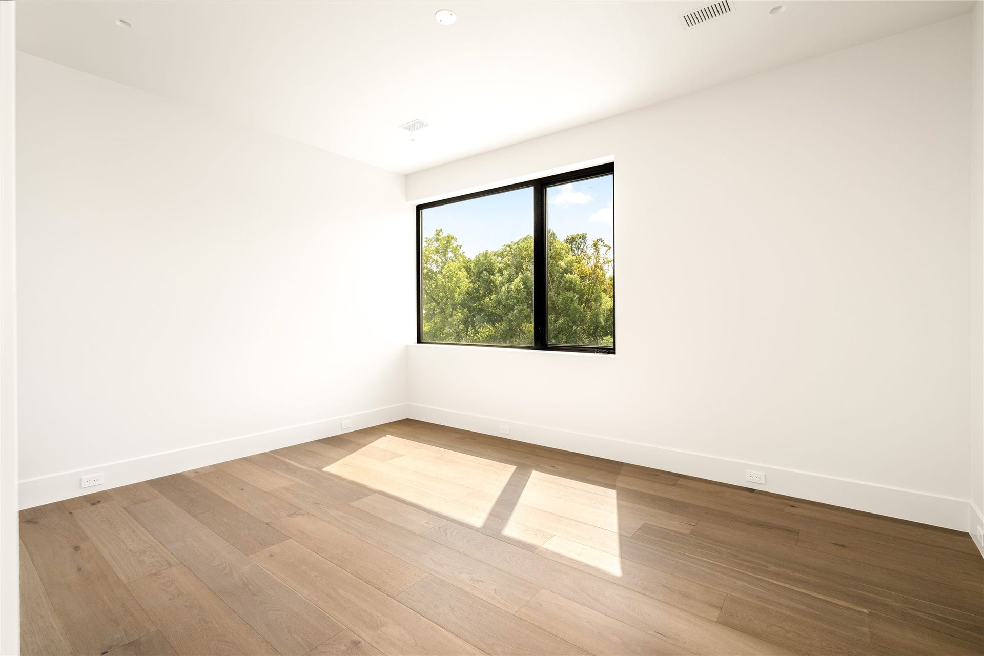 11 Tiel Way, Houston, TX 77019 Sunlight pours into this spacious bedroom suite through a large picture window, creating an airy atmosphere with plenty of flexibility for furniture placement.