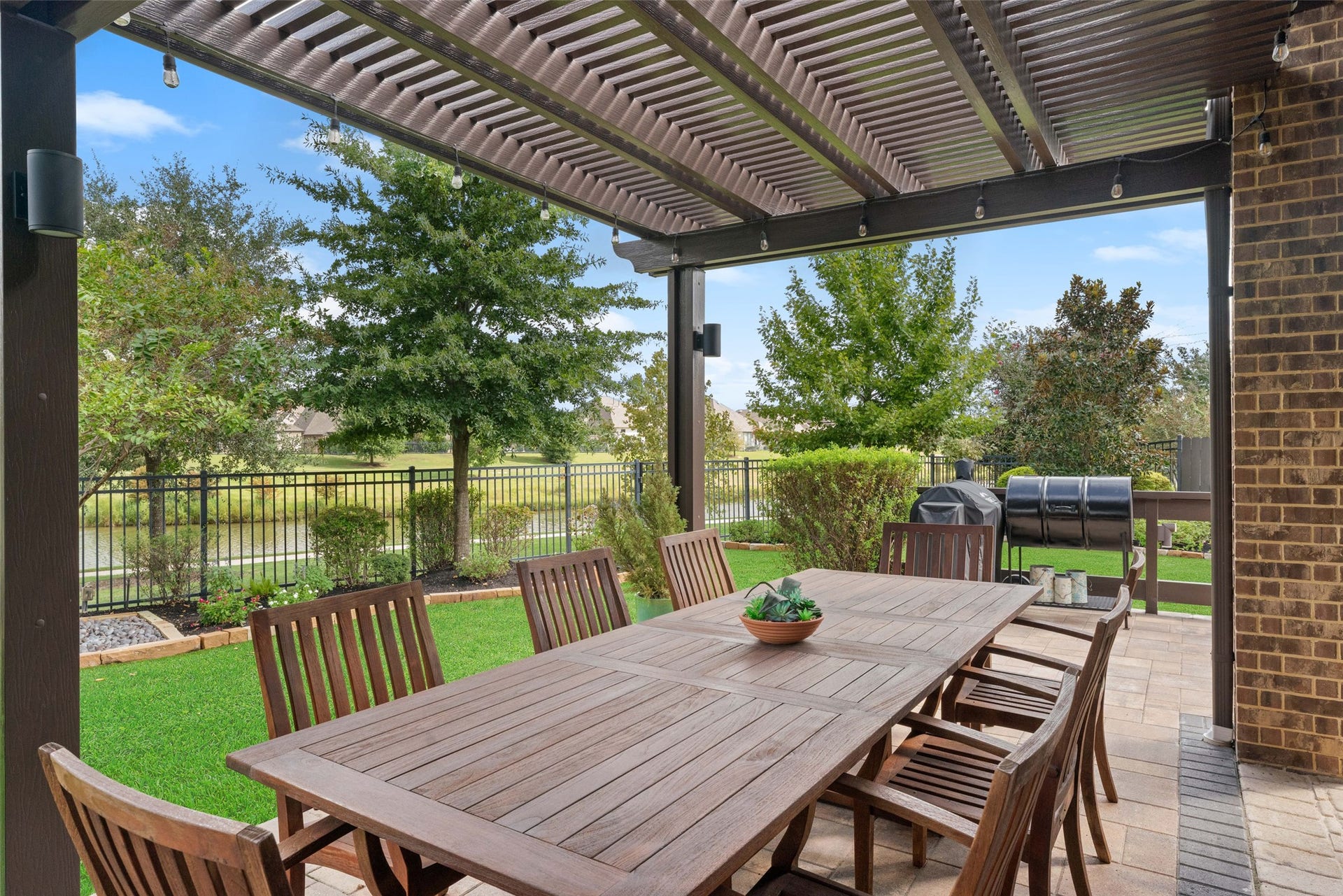 23926 Arcola Glen Lane, Katy, TX 77493 Modern two-tier metal pergola provides shade over the long outdoor dining table.