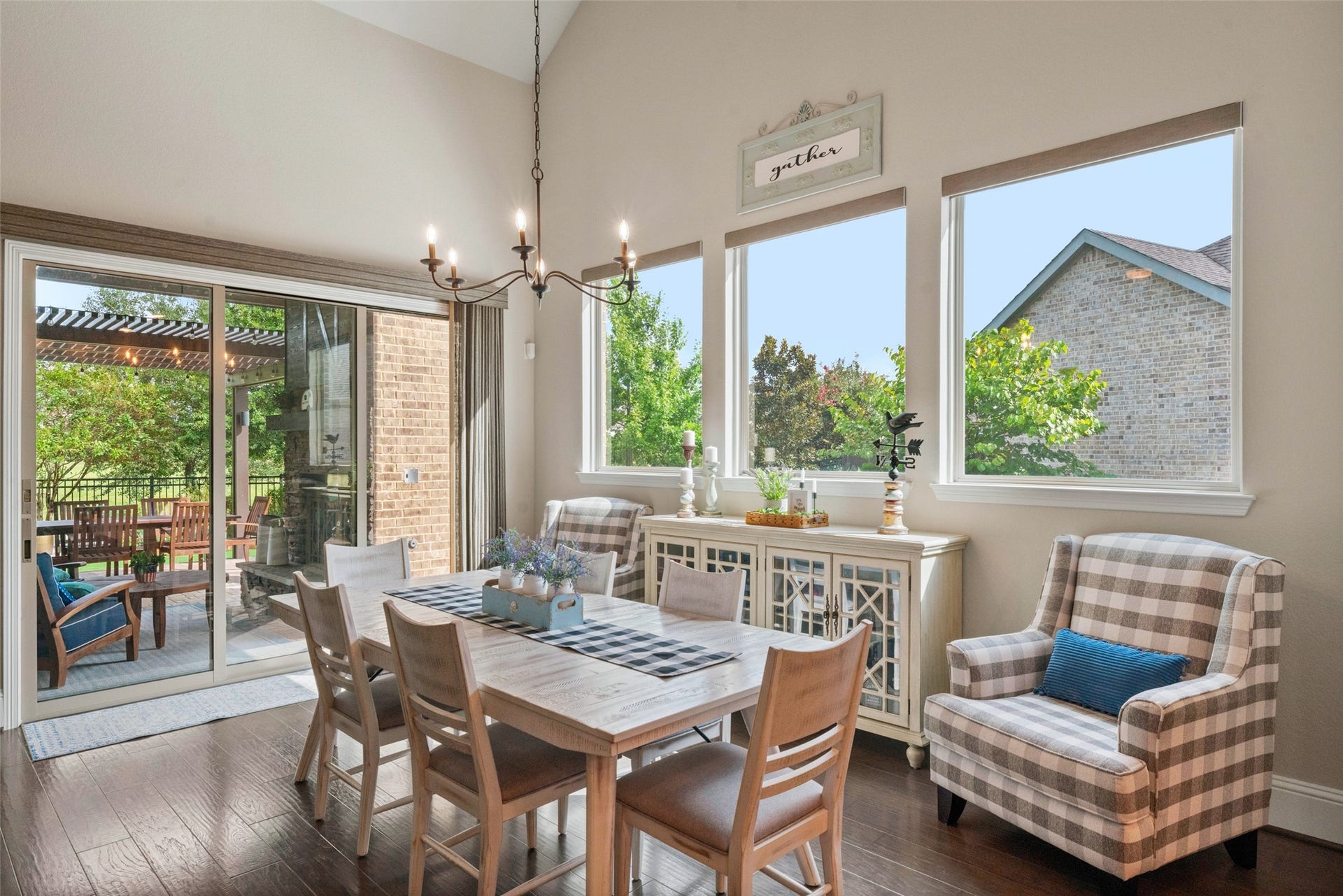 23926 Arcola Glen Lane, Katy, TX 77493 This dining room is open, light, and airy, featuring two walls of windows that offer beautiful natural light and scenic views. A modern farmhouse iron chandelier serves as the perfect centerpiece for this elegant space.