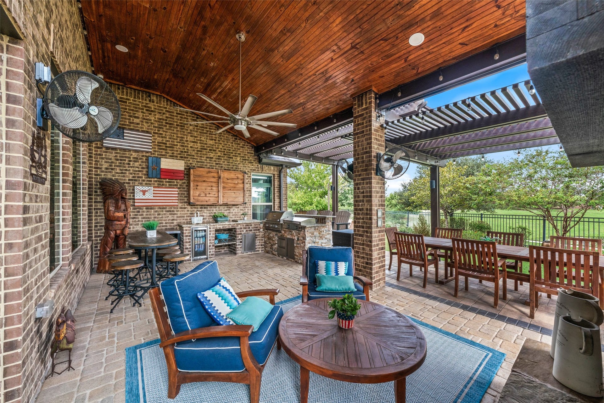 23926 Arcola Glen Lane, Katy, TX 77493 This inviting covered lanai offers a perfect space for relaxation, featuring multiple seating areas and ceiling fans for optimal comfort. The space is highlighted by a stunning premium stained tongue-and-groove ceiling.