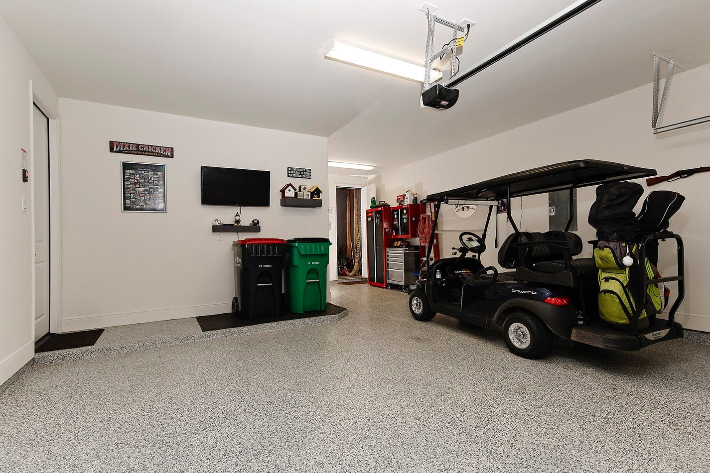 10135 Lehman Drive, Willis, TX 77318 Oversized two-car garage with additional space for a golf cart and dedicated storage.
