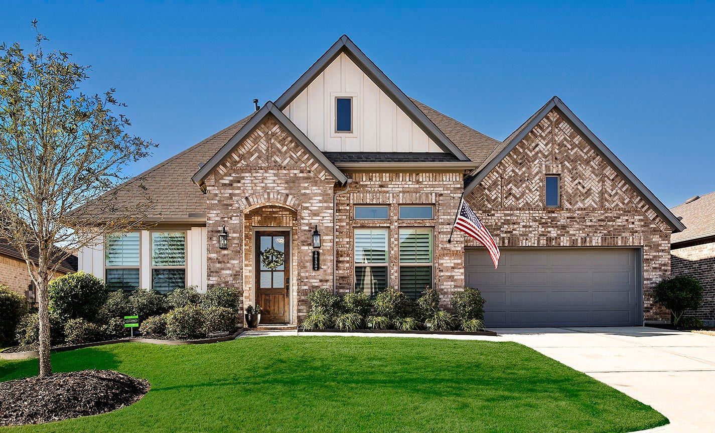 10135 Lehman Drive, Willis, TX 77318 This home features a stunning, inviting exterior that combines beautiful antique brick in unique patterns with modern vertical siding, creating a sophisticated and timeless curb appeal.