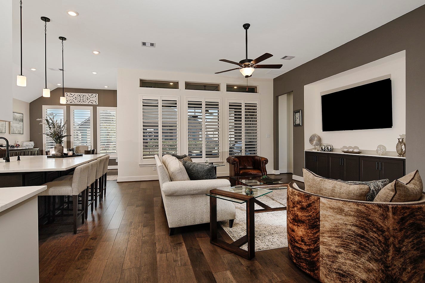 10135 Lehman Drive, Willis, TX 77318 This home features an open-concept floor plan designed for seamless entertaining and family interaction. The striking wall of windows, accented by plantation shutters and transoms, offers a beautiful view of the covered lanai.