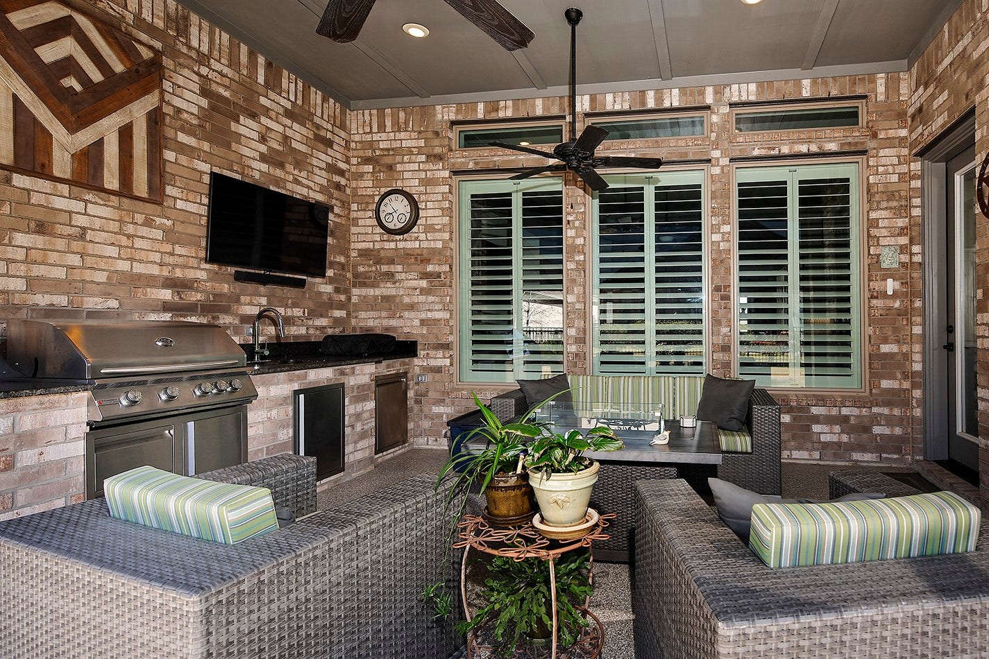 10135 Lehman Drive, Willis, TX 77318 Gorgeous covered lanai featuring a fully equipped outdoor kitchen with a built-in grill and plenty of space for lounge furniture, perfect for outdoor entertaining.