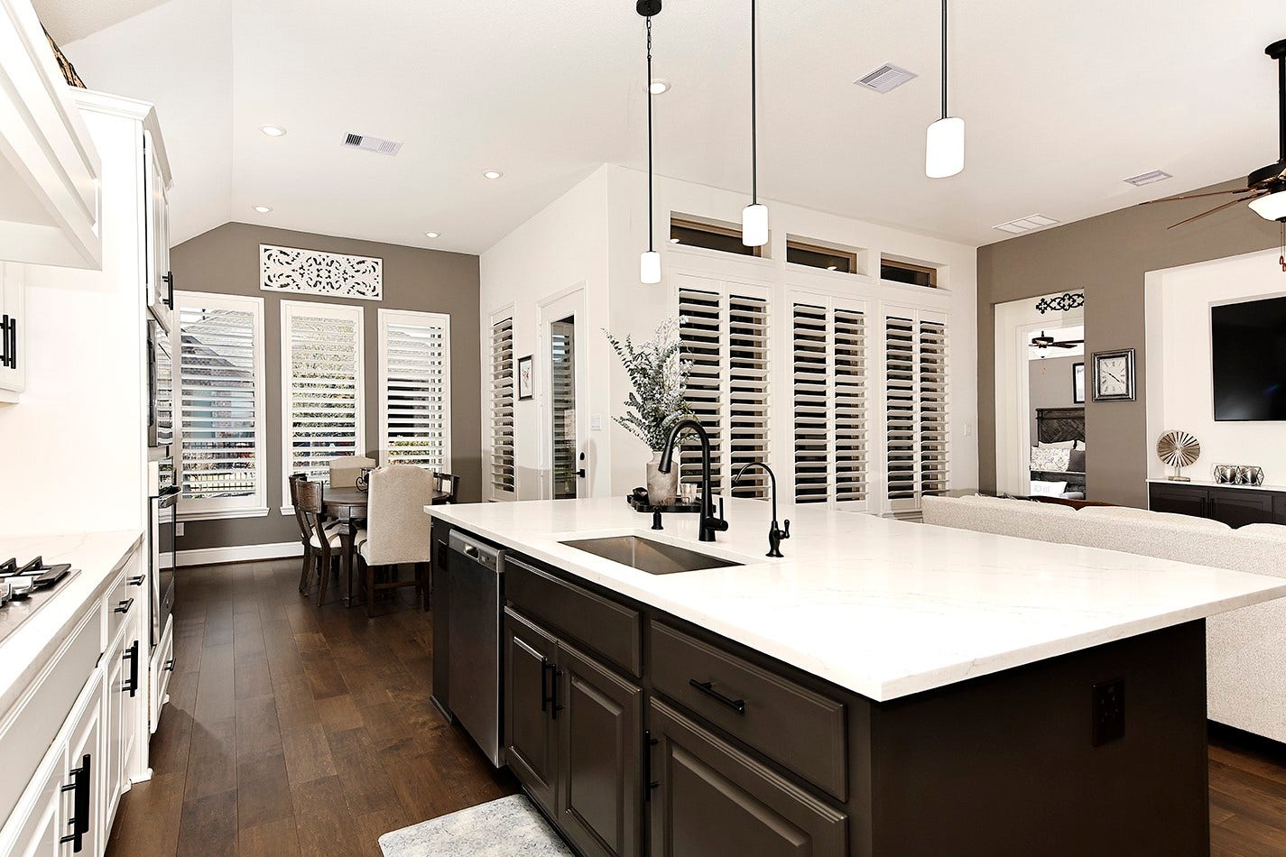 10135 Lehman Drive, Willis, TX 77318 The kitchen island features rich-toned cabinetry that complements the darker wall color and beautiful wood flooring throughout the space.