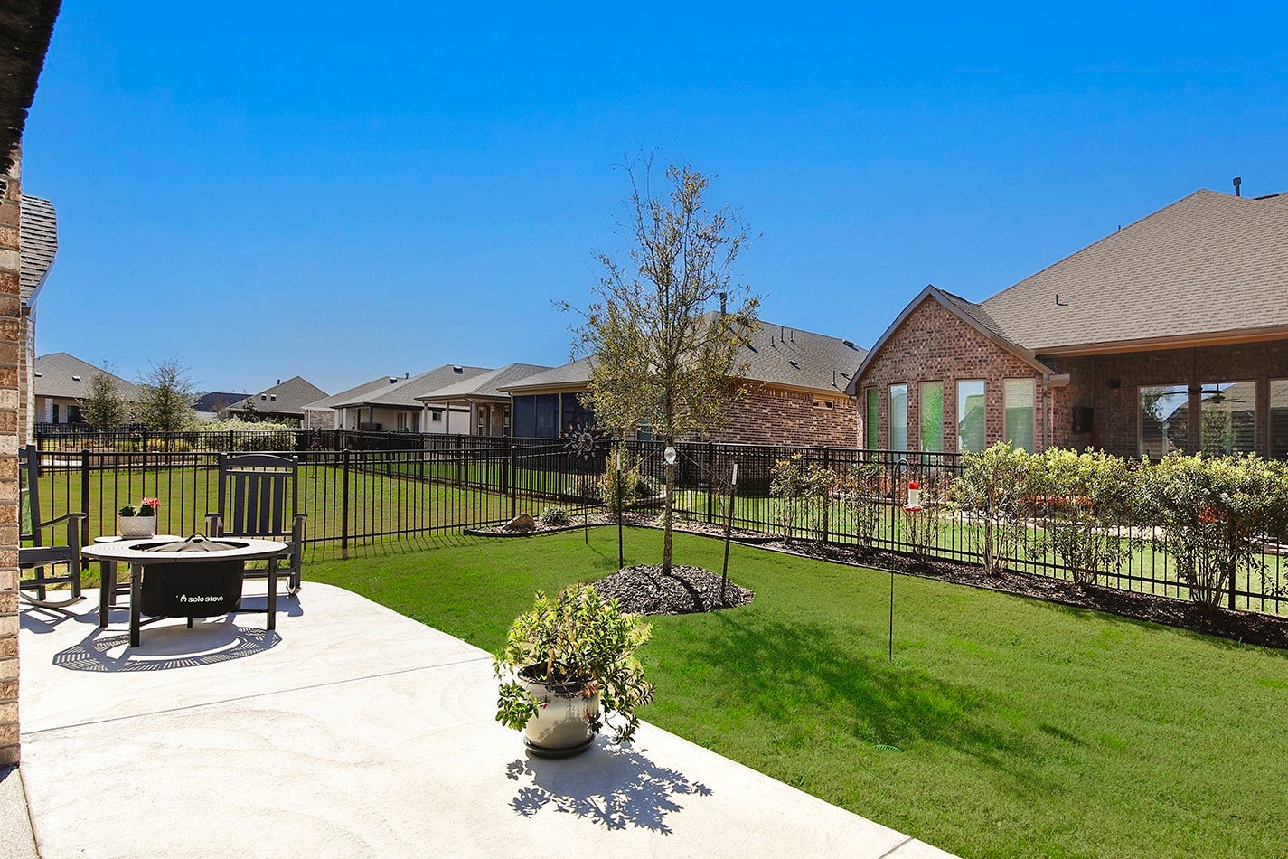 10135 Lehman Drive, Willis, TX 77318 Extended concrete patio perfect for a firepit, rocking chairs, and sun-loving potted plants.