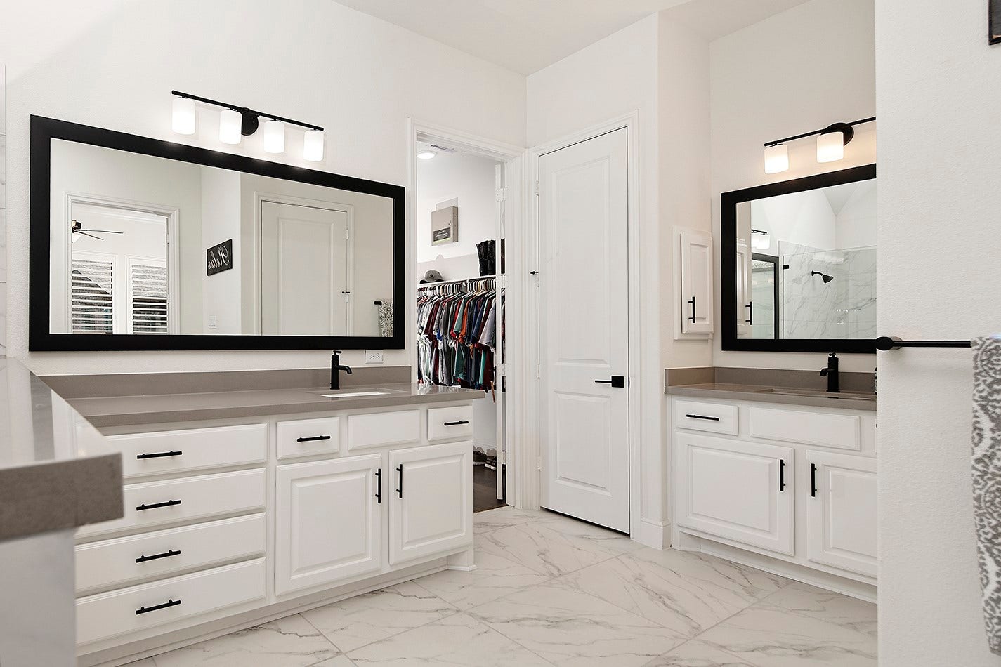 10135 Lehman Drive, Willis, TX 77318 The primary bath has a highly desirable layout with separate vanity areas, offering ample counter and cabinet storage accented by modern black pulls, fixtures, and sleek mirrors.