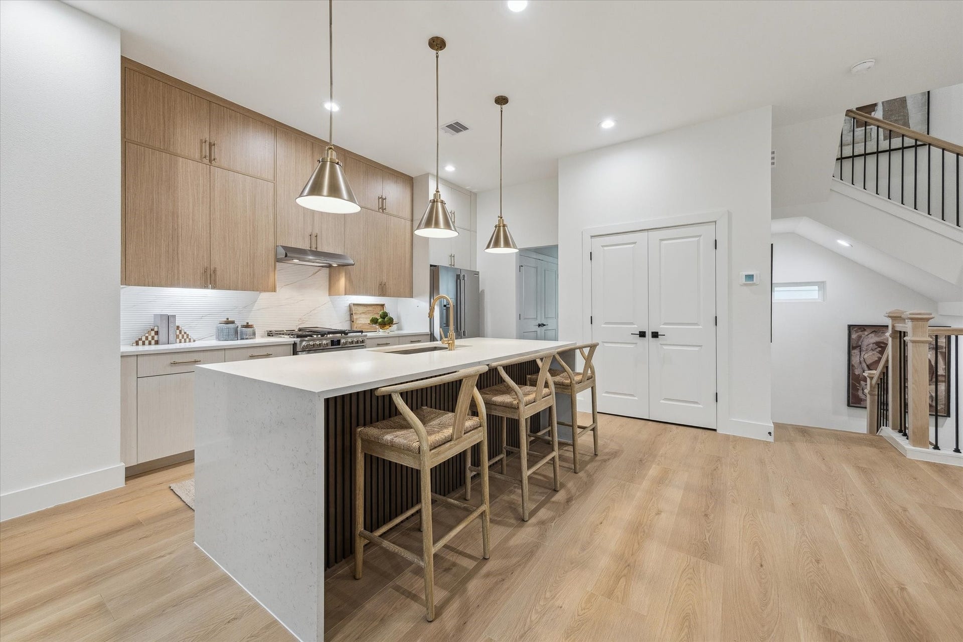 Elegant kitchen featuring a spacious island with seating, sleek cabinetry, and modern pendant lighting, seamlessly blending style and functionality.