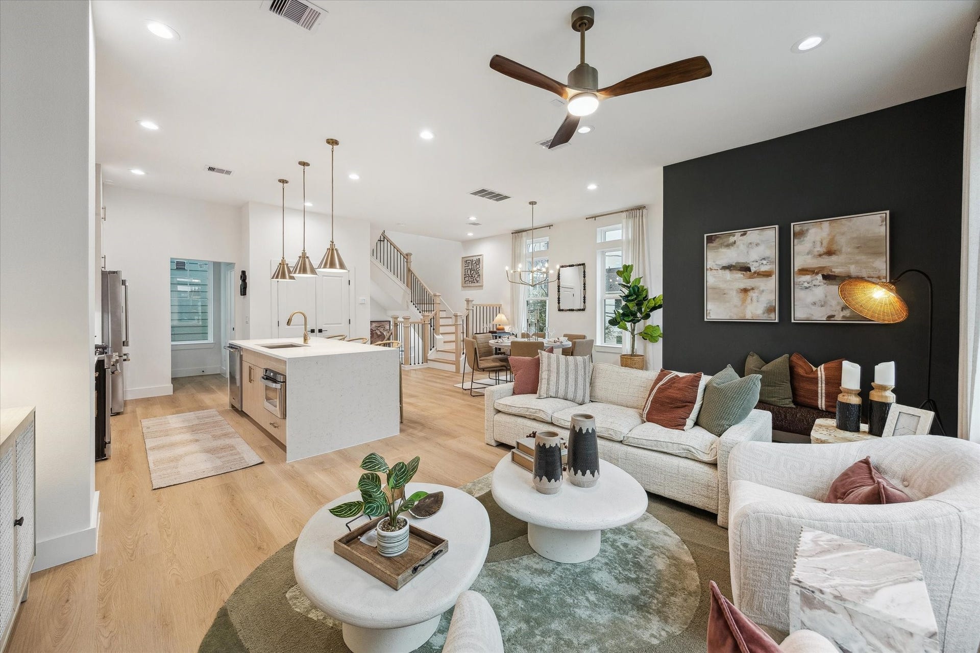 Spacious open-concept living area with modern finishes, featuring a sleek kitchen island, cozy seating, and elegant lighting, perfect for entertaining.