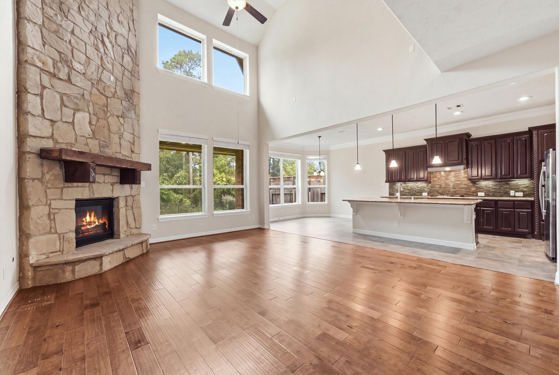 13920 N Lake Branch Lane, Houston, TX 77044 Living room with floor to ceiling stacked stone fireplace - opens to kitchen and breakfast room beyond
