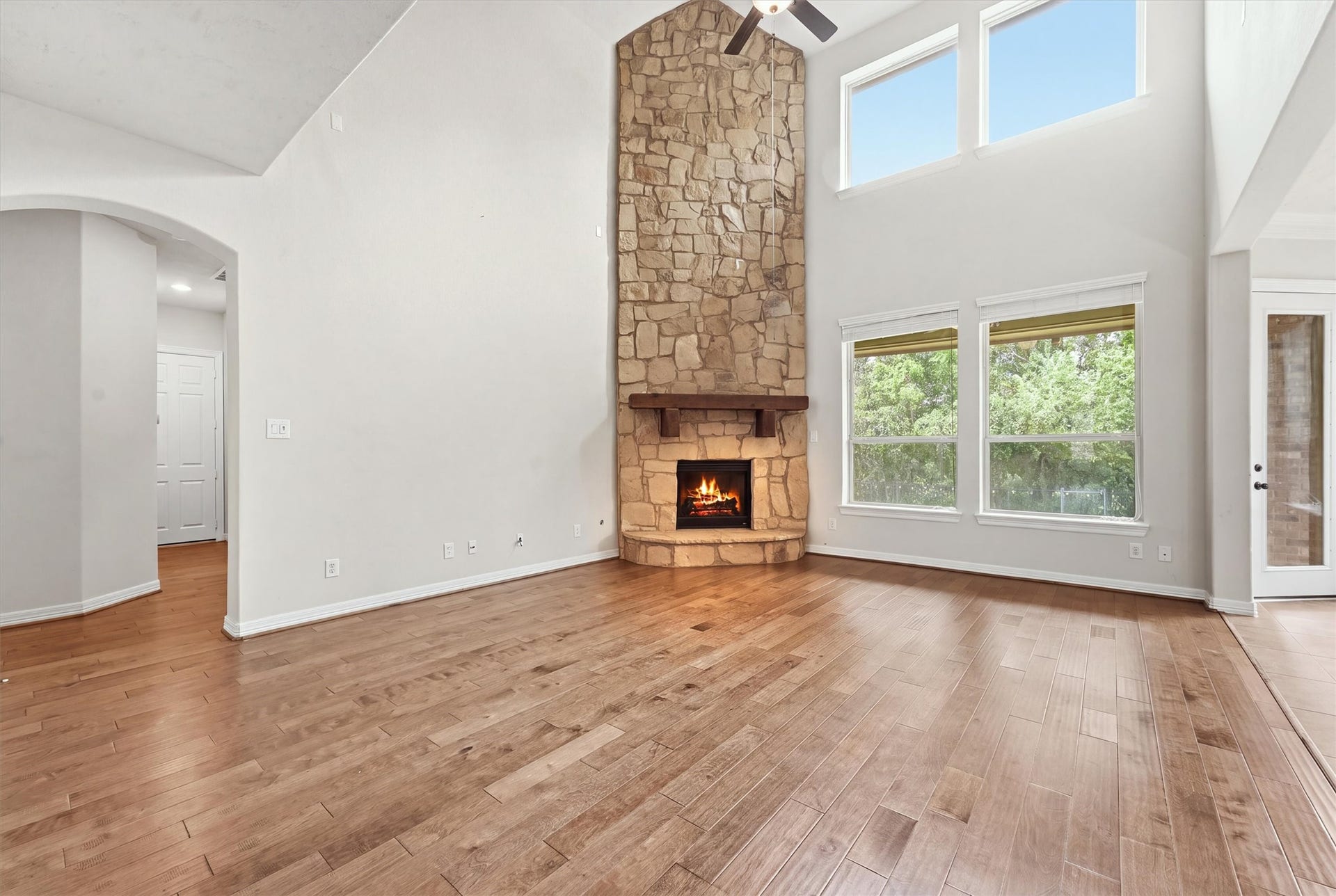 13920 N Lake Branch Lane, Houston, TX 77044 Another view of the living room, featuring large windows,floor to ceiling stacked stone fireplace and beautiful wood floors