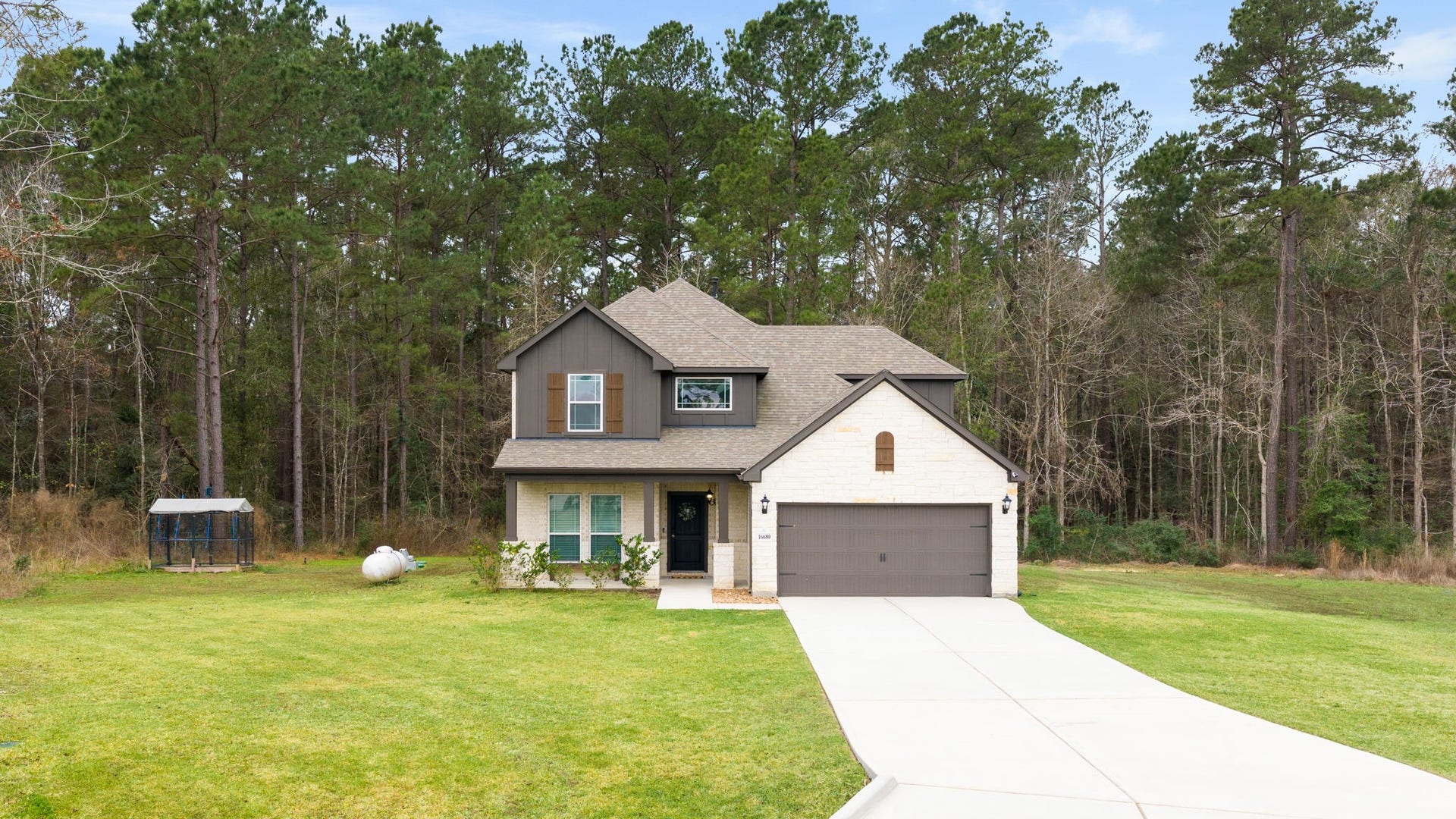 16680 Rockwall Street, Conroe, TX 77303 This home features an elevated CE floorplan with beautiful stone and brick front and a large covered front porch.