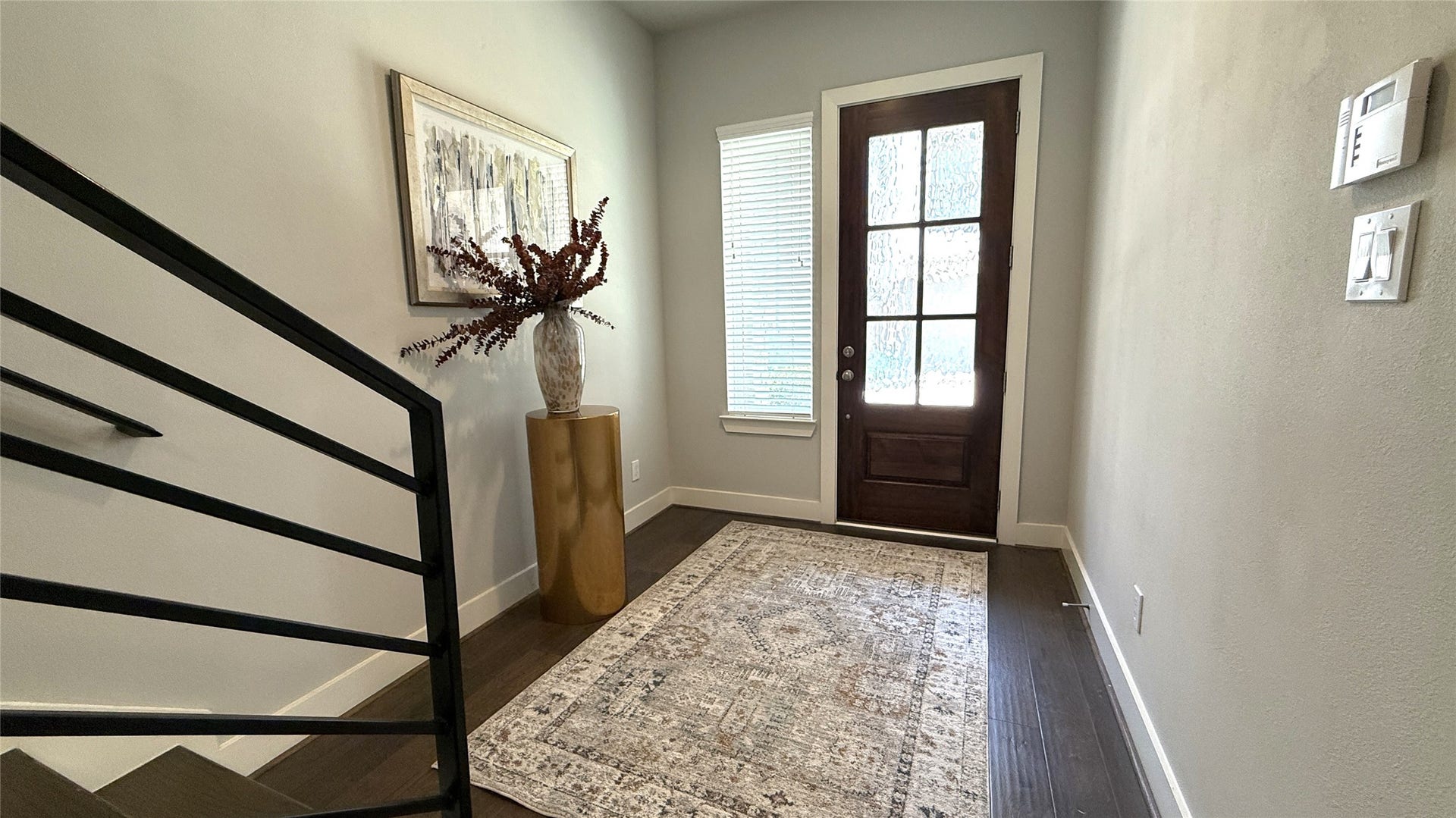 Beautiful entry with wood floors, 10ft ceilings & iron railings