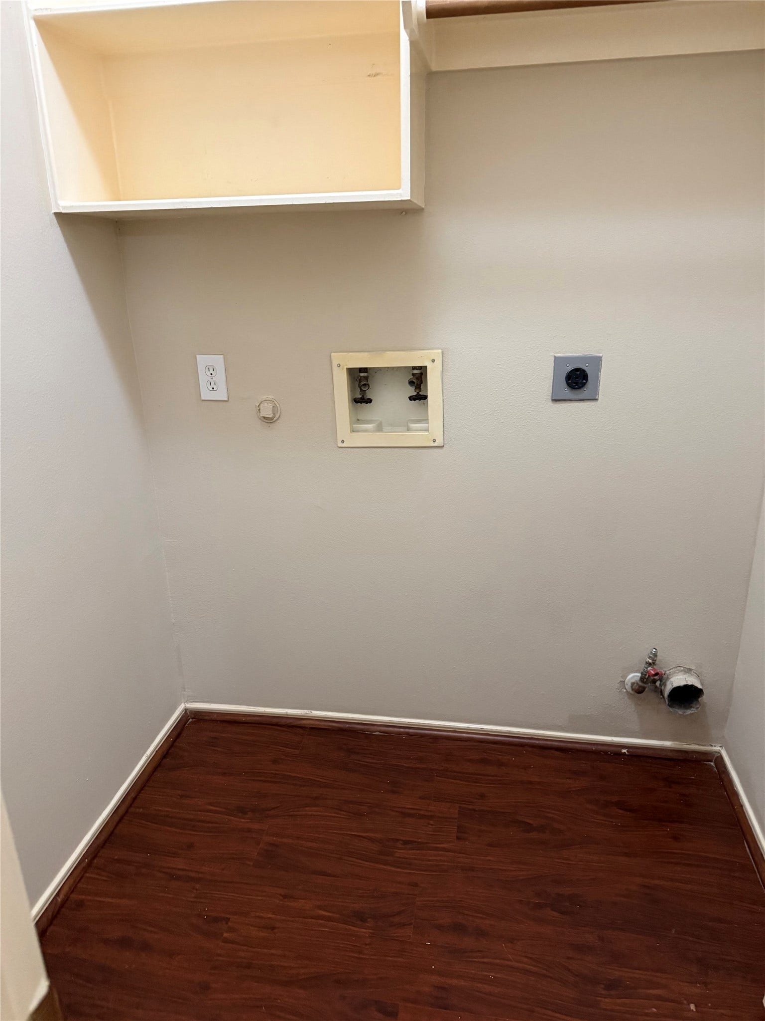 2104 Goldfinch Lane, League City, TX 77573 Spacious laundry room with hookups, featuring a convenient wall shelf and durable wood flooring.
