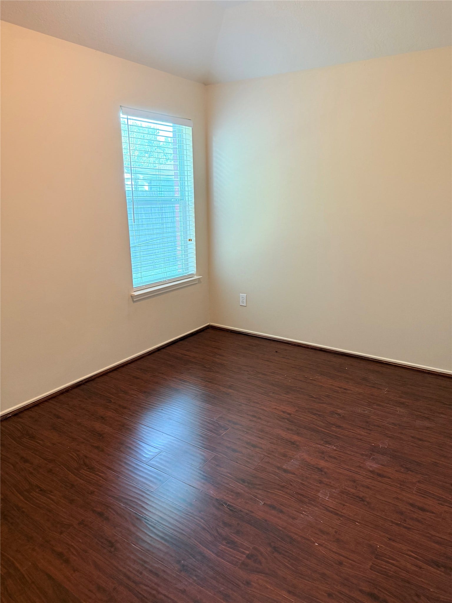 2104 Goldfinch Lane, League City, TX 77573 Cozy room with rich wood flooring and a large window providing natural light, perfect for a bedroom or home office.