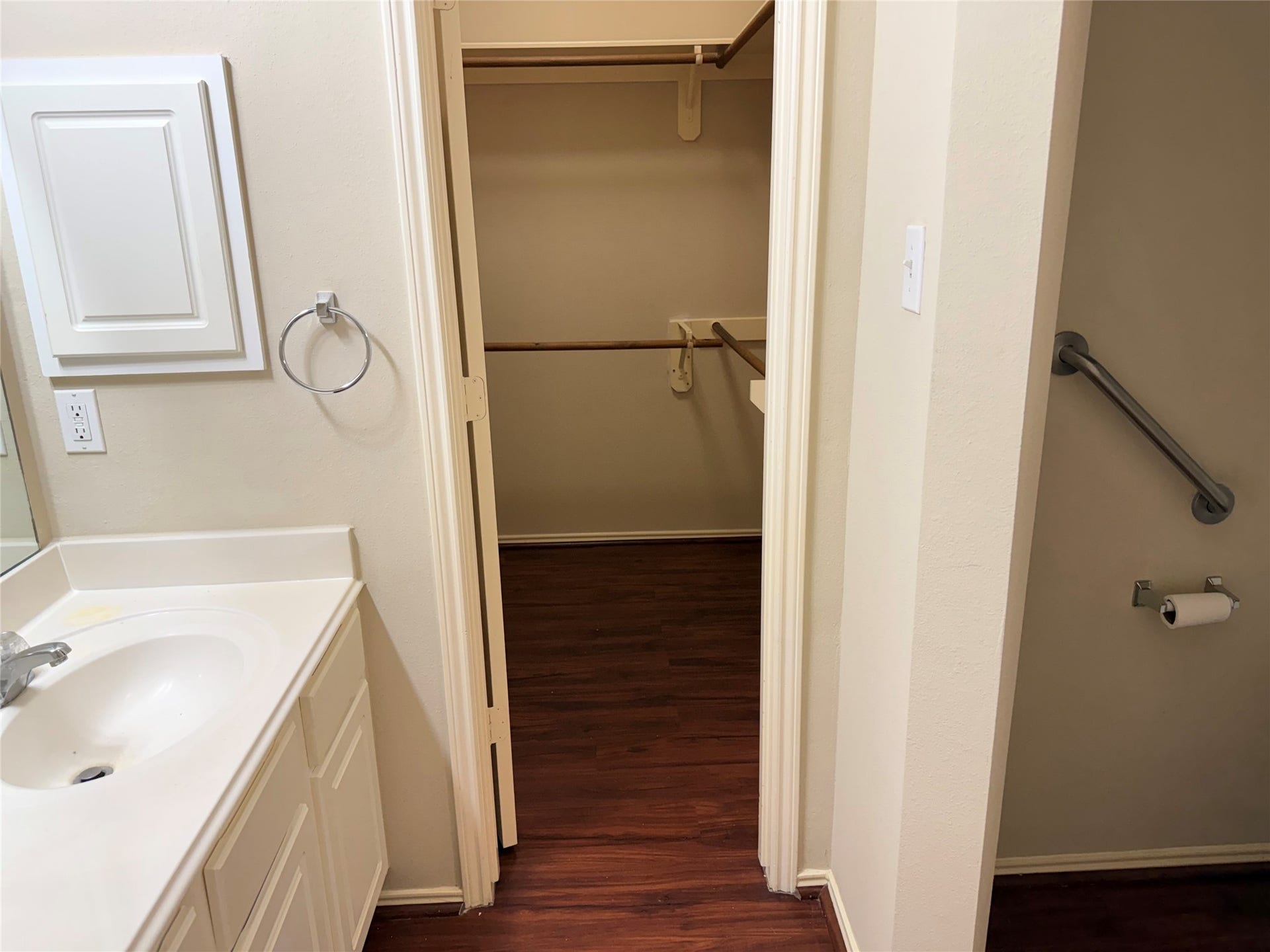 2104 Goldfinch Lane, League City, TX 77573 Spacious bathroom with a clean, white vanity leading to a large walk-in closet featuring rich wooden flooring.