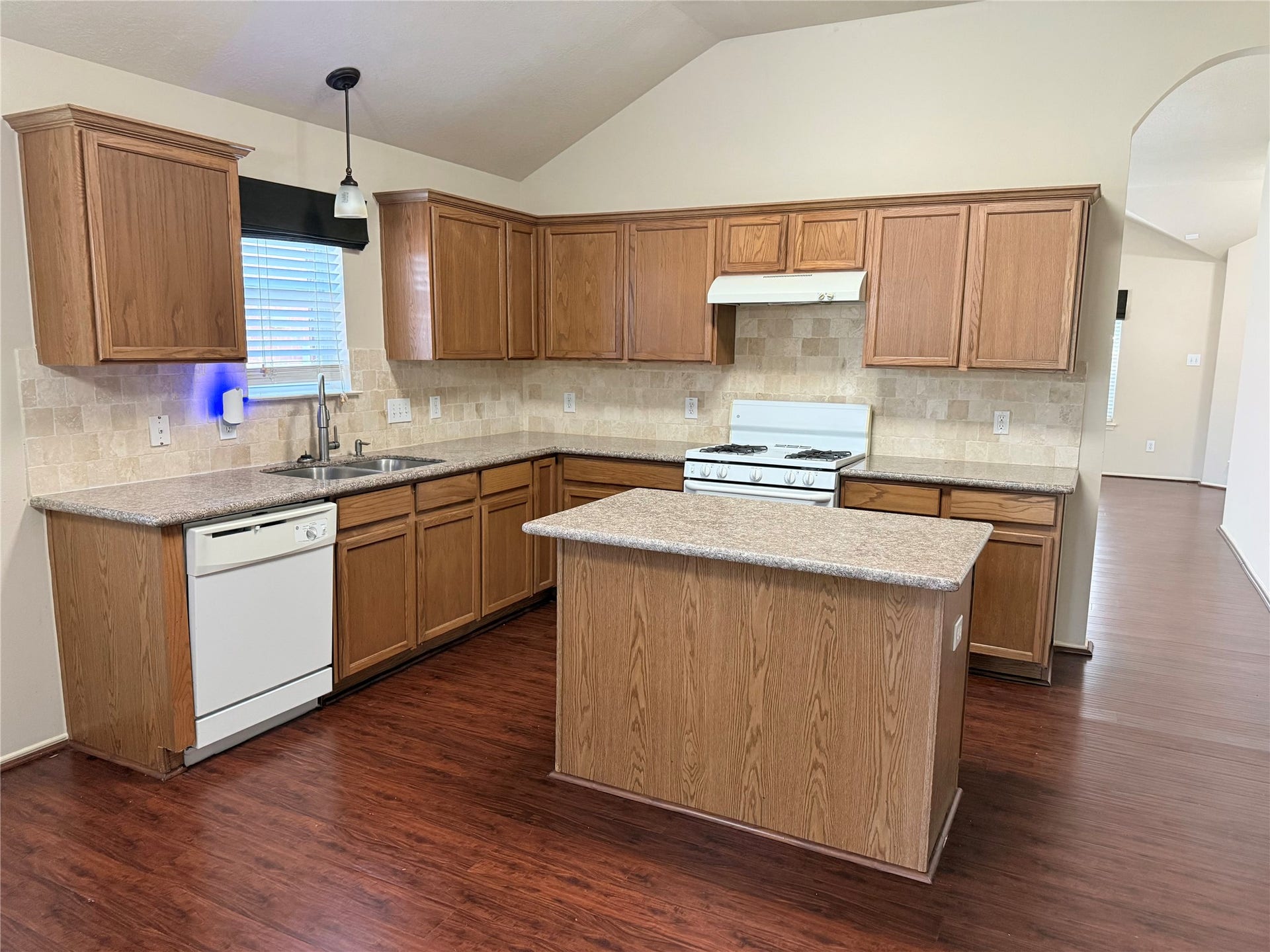 2104 Goldfinch Lane, League City, TX 77573 Spacious kitchen with warm wood cabinetry, a central island, and modern appliances, perfect for family gatherings and meal prep.