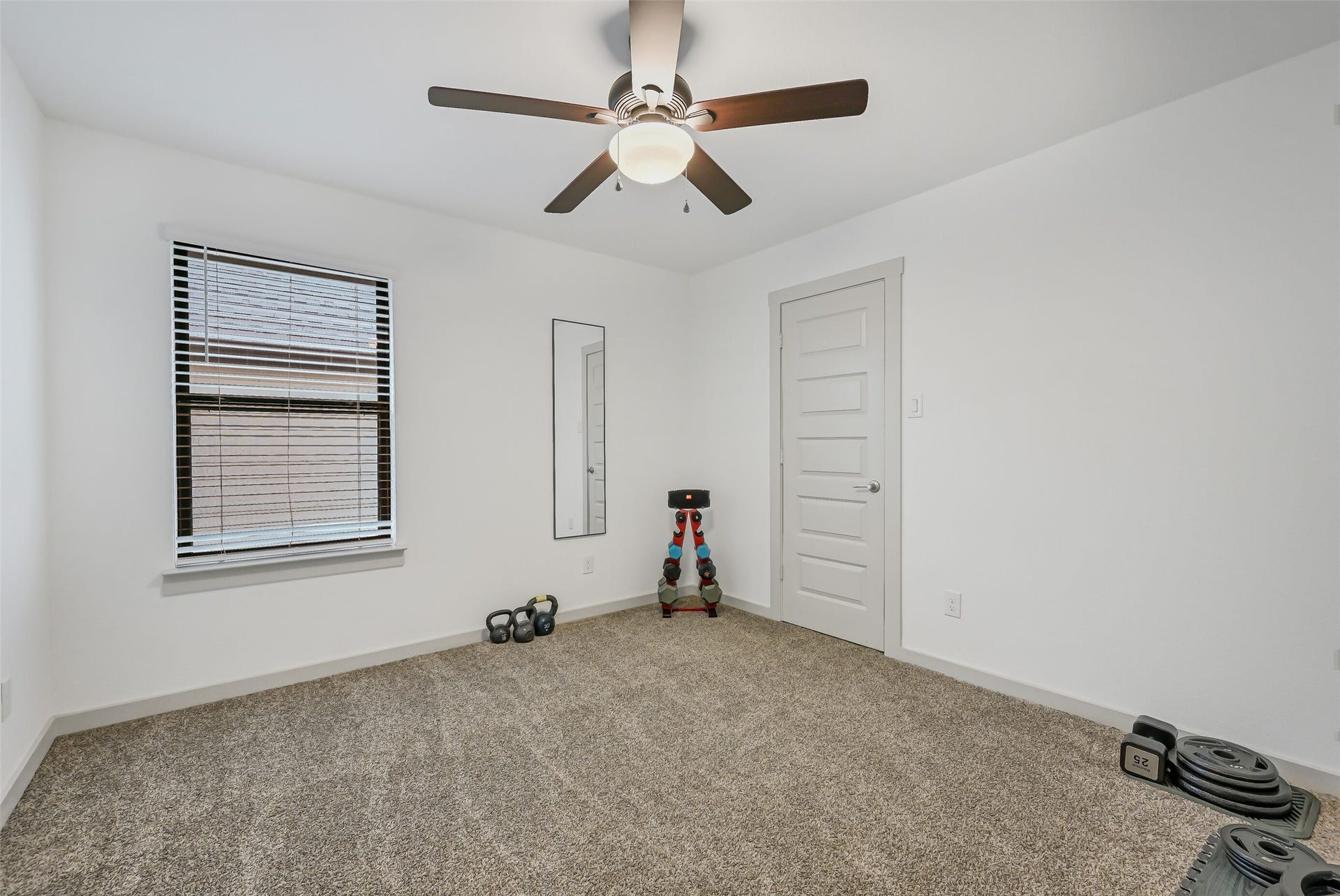 1570 Mustang Trail, Friendswood, TX 77546 One of the home's generously sized secondary bedrooms offers neutral finishes, plush carpet, a ceiling fan, and ample floor spacecomfortable as a bedroom while also offering the flexibility to serve as a hobby room, exercise space, or additional office.