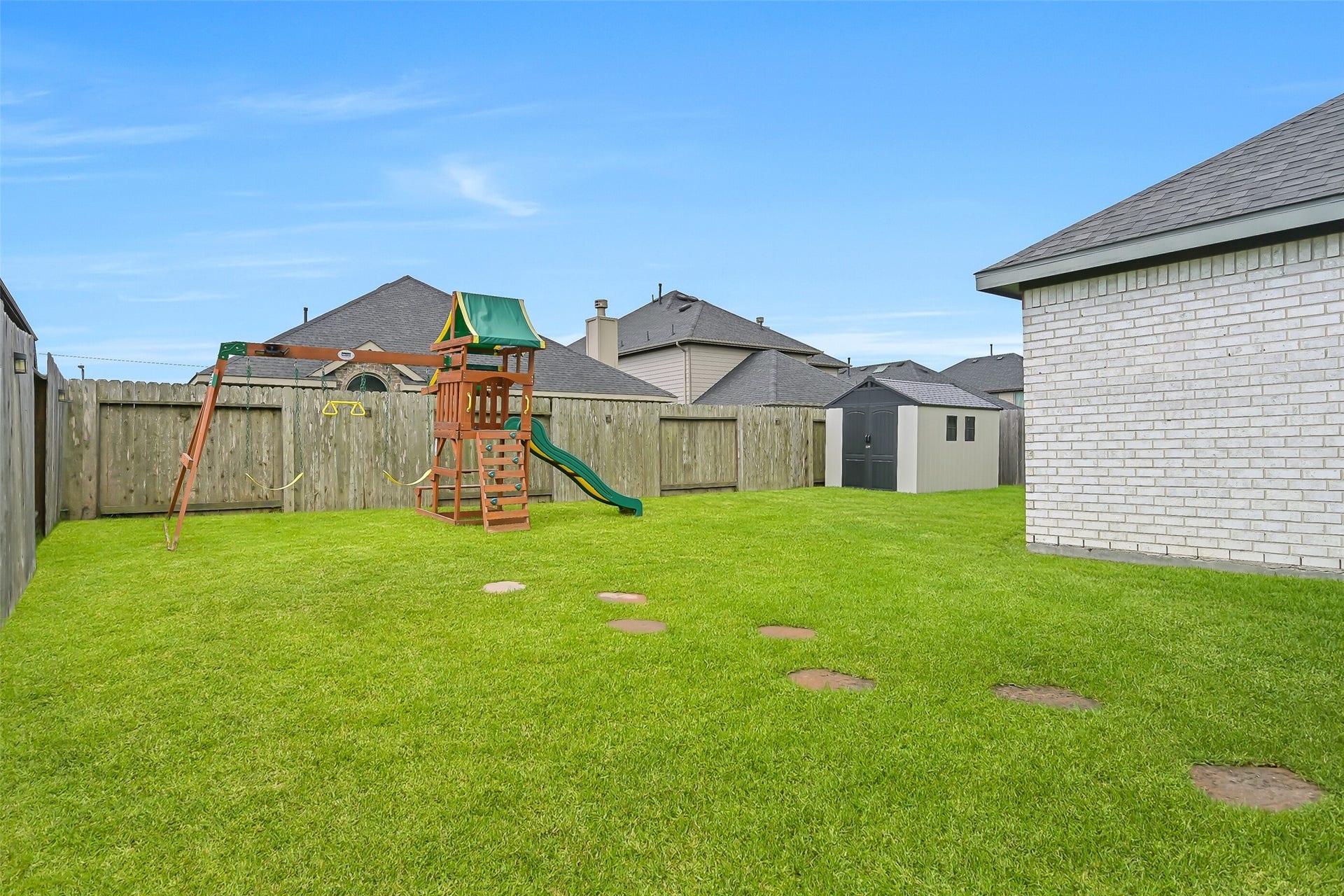 1570 Mustang Trail, Friendswood, TX 77546 Theres plenty of room to play in this fully fenced backyard! A large grassy lawn surrounds the existing playset, while a storage shed keeps lawn equipment and outdoor gear tucked away. Stepping stones create a charming pathway across the yard.