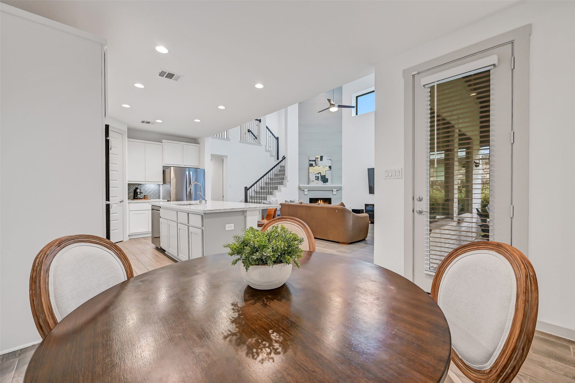 1570 Mustang Trail, Friendswood, TX 77546 Looking back from the breakfast area reveals just how beautifully the main living spaces connect, with the kitchen island, soaring family room, statement fireplace, and staircase all within viewan open layout filled with natural light.