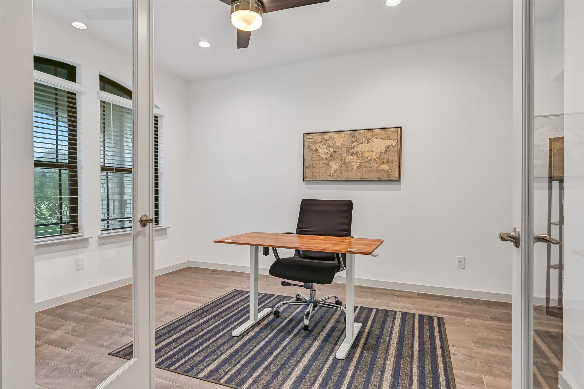 1570 Mustang Trail, Friendswood, TX 77546 Positioned just off the foyer, the private home office features glass French doors, recessed lighting, a ceiling fan, wood-look tile flooring, and tall front-facing windowscreating a bright, comfortable space for working or studying from home.