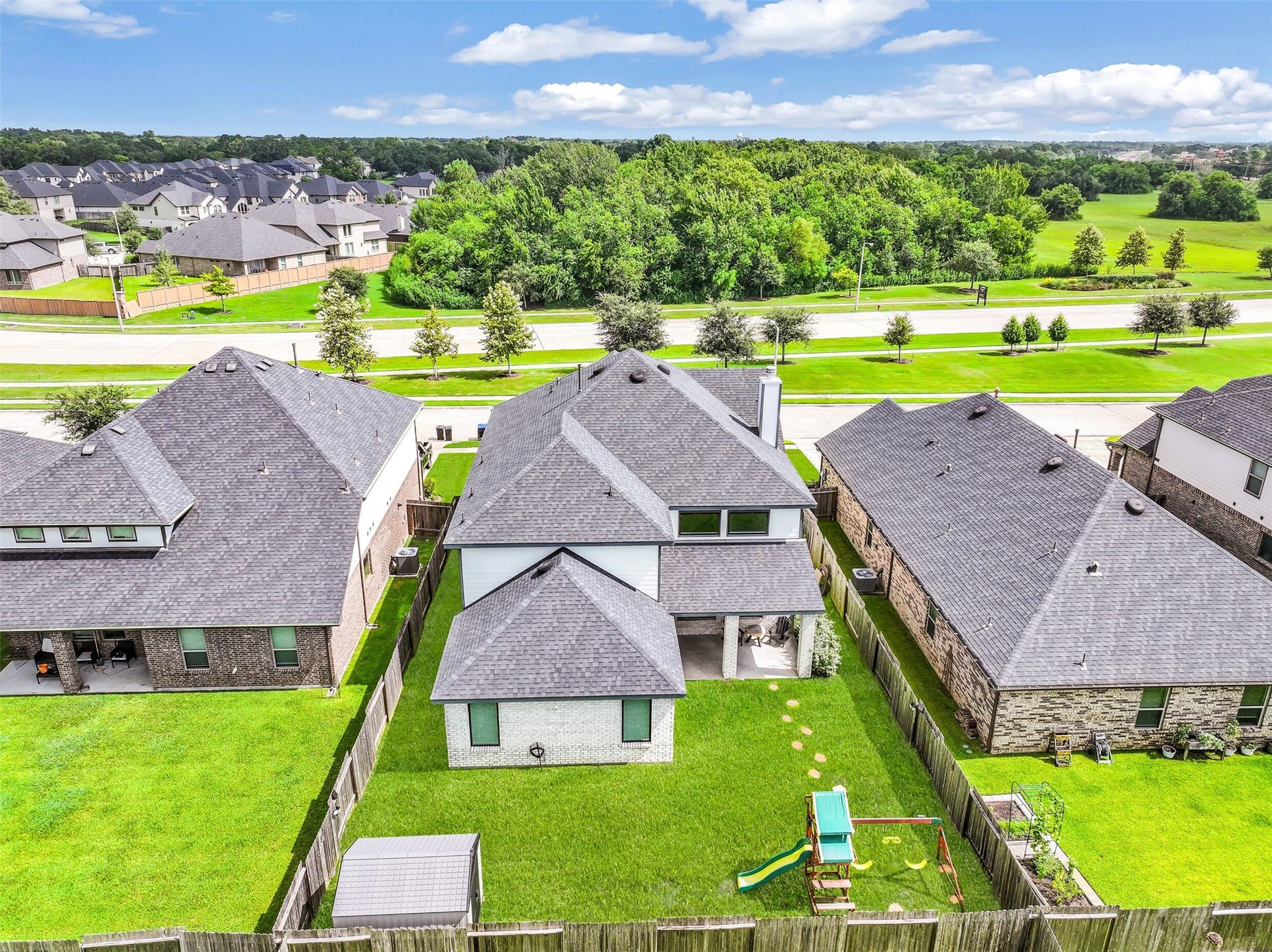 1570 Mustang Trail, Friendswood, TX 77546 This aerial view showcases the home's footprint, covered patio, fenced backyard, playset, storage shed, and generous lawn space while also providing a great perspective on its setting within established Friendswood Trails.