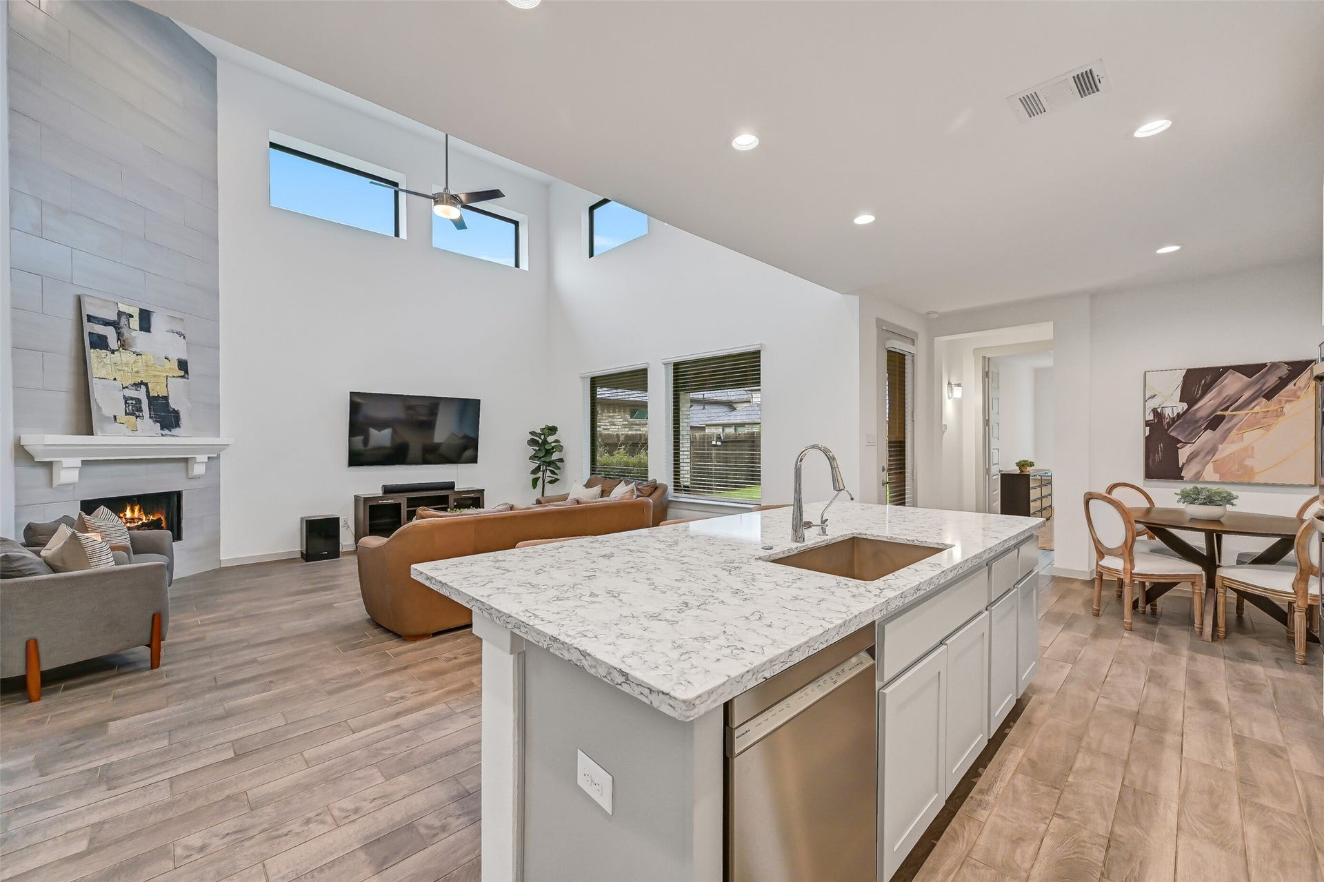 1570 Mustang Trail, Friendswood, TX 77546 From the kitchen, enjoy an unobstructed view into the soaring family room and adjoining breakfast area. The oversized island anchors the open-concept layout, creating an easy connection between the home's primary gathering spaces.