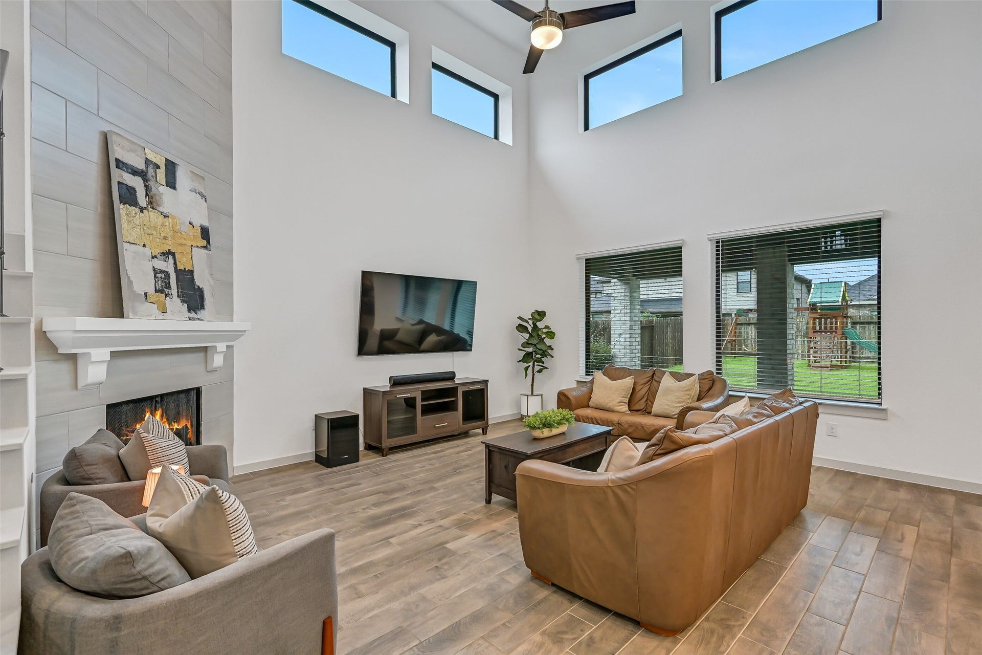 1570 Mustang Trail, Friendswood, TX 77546 Another angle showcases the impressive scale of the two-story family room, where oversized windows and upper clerestory windows fill the space with natural light. The open layout flows seamlessly into the adjoining kitchen and breakfast area.