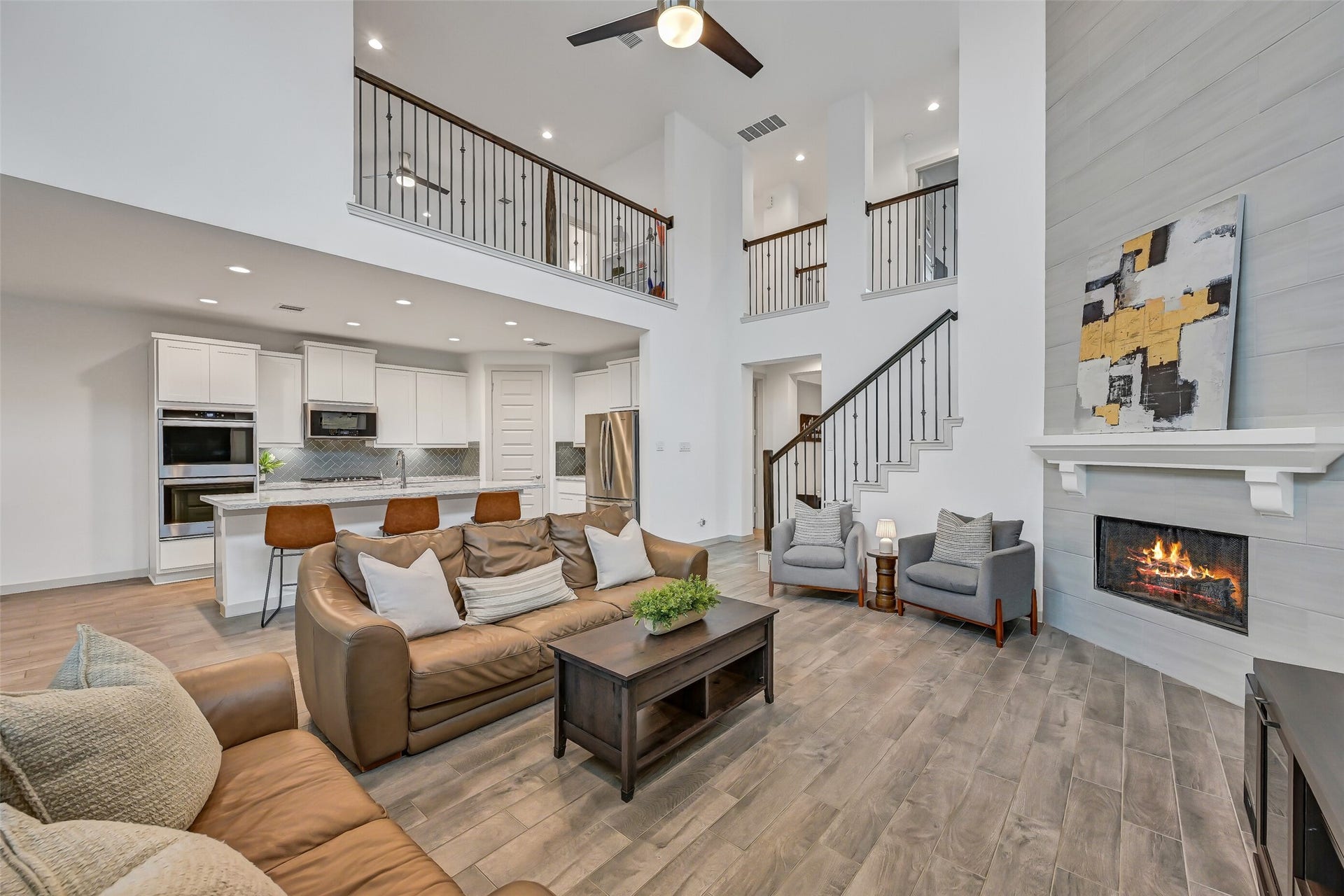 1570 Mustang Trail, Friendswood, TX 77546 Designed with connection in mind, the spacious family room opens directly to the island kitchen while the iron-railed staircase and upstairs overlooks add architectural interest. The floor-to-ceiling fireplace creates a dramatic focal point for the entire space.