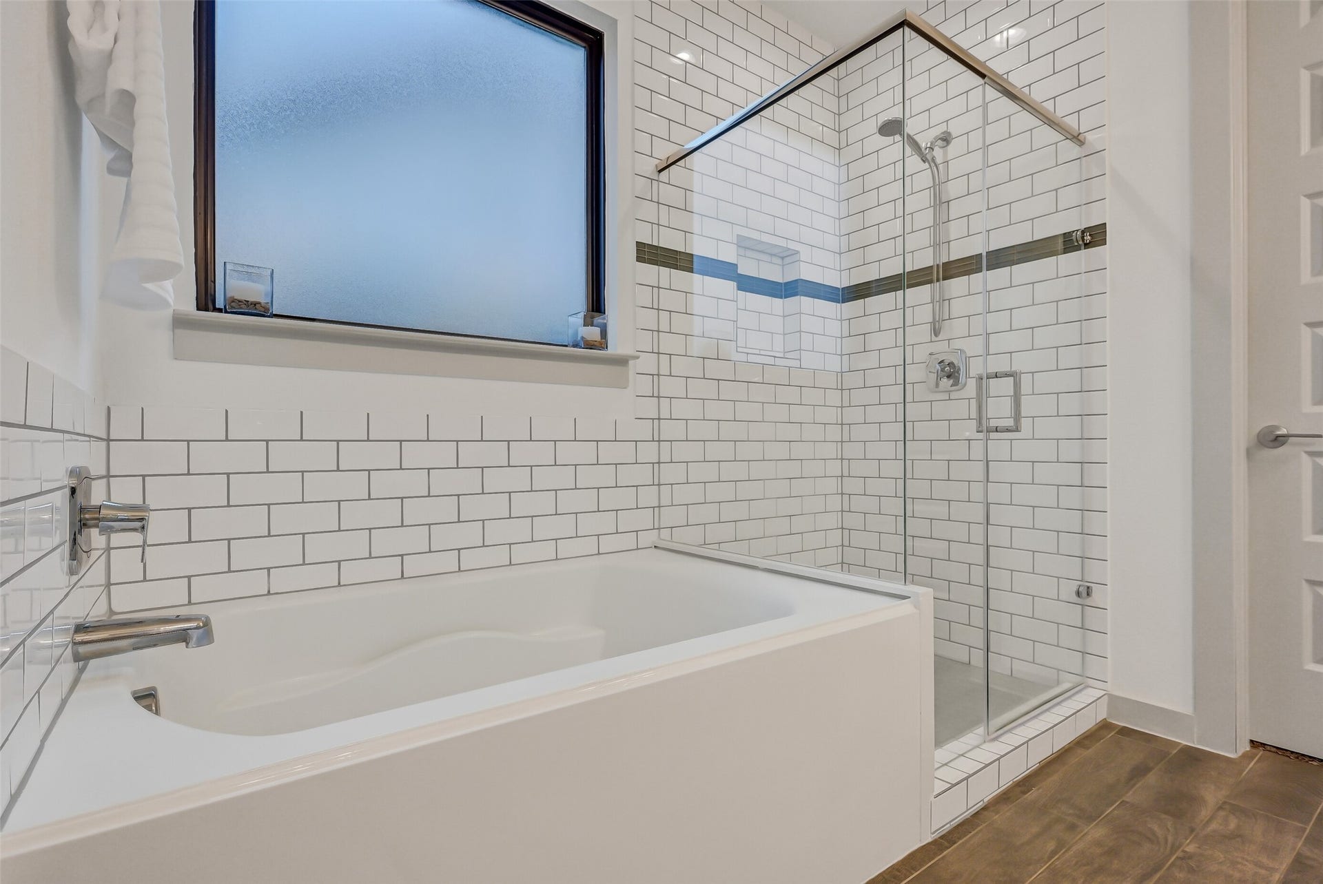 1570 Mustang Trail, Friendswood, TX 77546 Relax in the soaking tub or step into the oversized frameless glass shower, surrounded by crisp subway tile with a contrasting accent band. A large frosted window brings natural light into this beautifully appointed primary bath while maintaining privacy.
