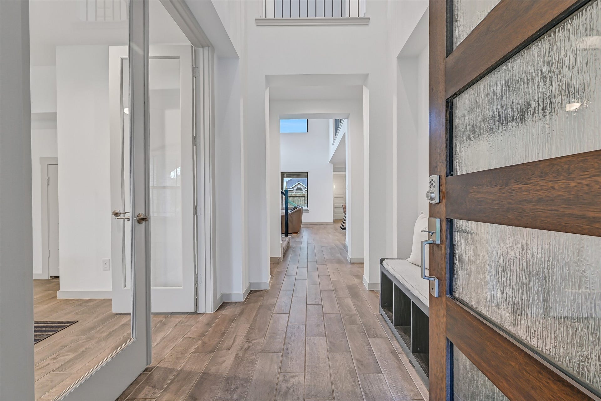 1570 Mustang Trail, Friendswood, TX 77546 Step inside to soaring ceilings, wood-look tile flooring, crisp neutral finishes, and an impressive sightline extending from the foyer into the dramatic two-story family room. Glass French doors open to the private home office just off the entry.