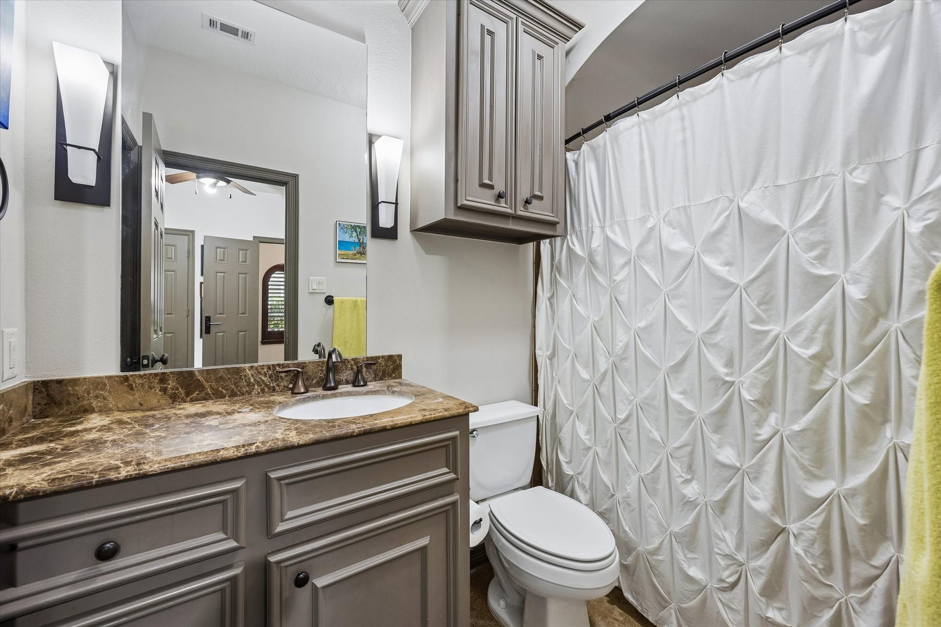 ...an en-suite Bath with custom cabinetry, dark emperador marble counters, a tub/shower combination and a head-knocker.