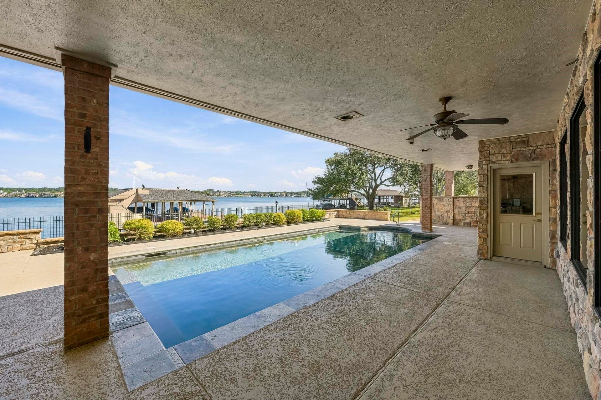 9354 Escondido Drive, Willis, TX 77318 Your own waterfront retreat! Relax beside the sparkling pool or unwind beneath the expansive covered patio while taking in panoramic Lake Conroe views.