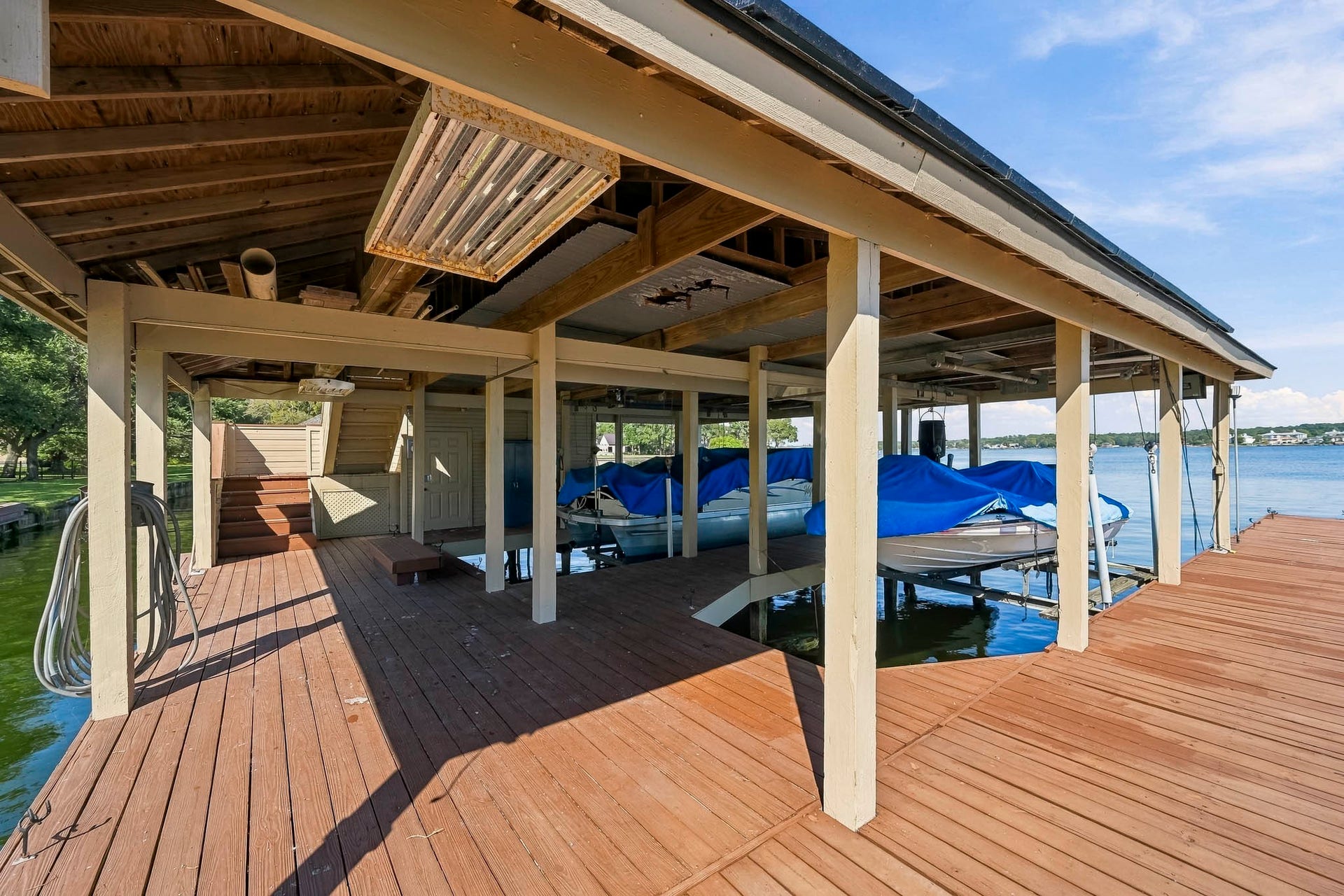 9354 Escondido Drive, Willis, TX 77318 Take lake living to another level! Stairs lead to the boathouse's upper sundeck, offering an elevated space to relax and enjoy the waterfront setting. Boats not included.