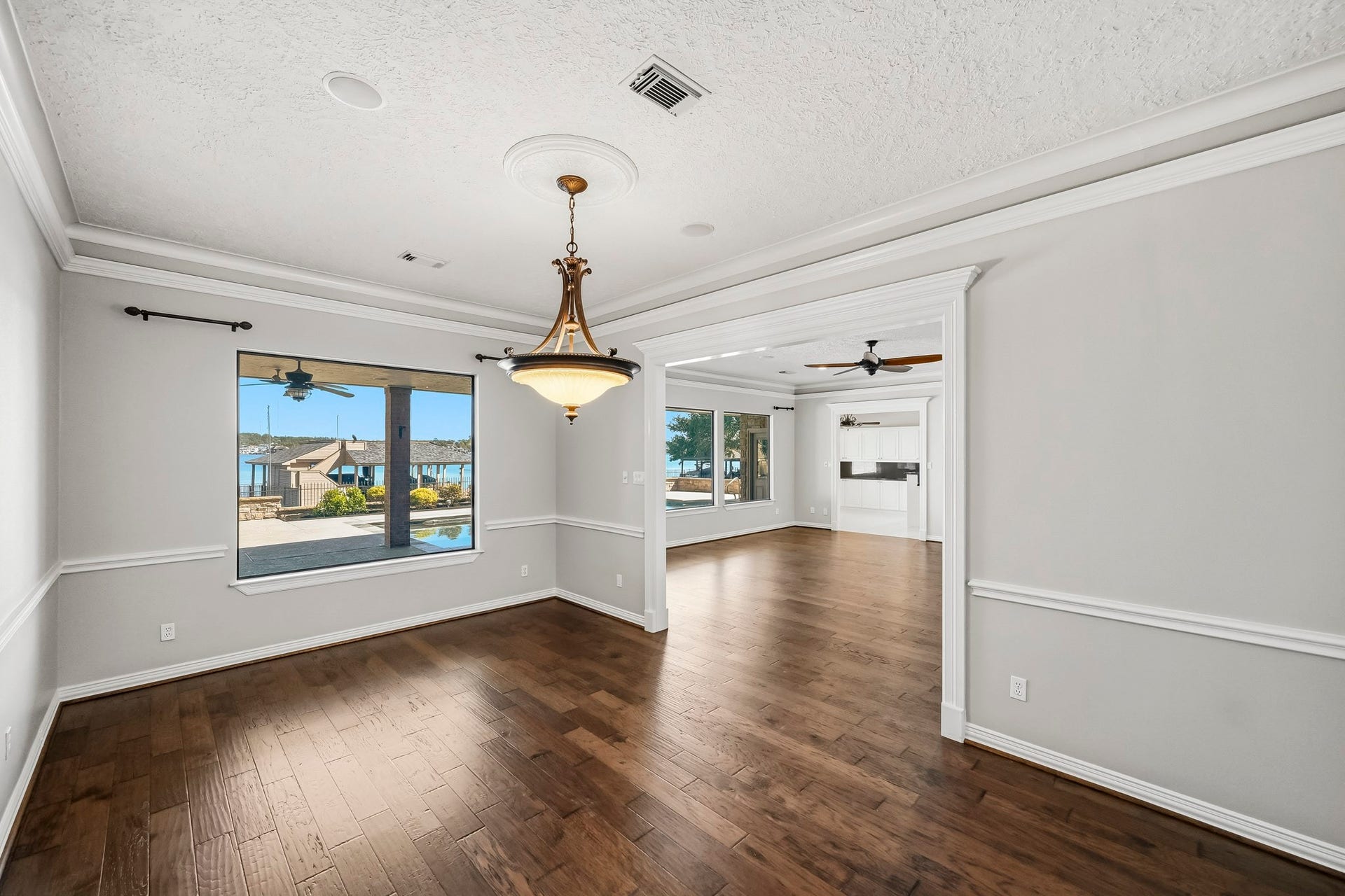 9354 Escondido Drive, Willis, TX 77318 Dine with a view! A large window overlooks the pool and Lake Conroe, while a wide opening provides easy access to the living room.