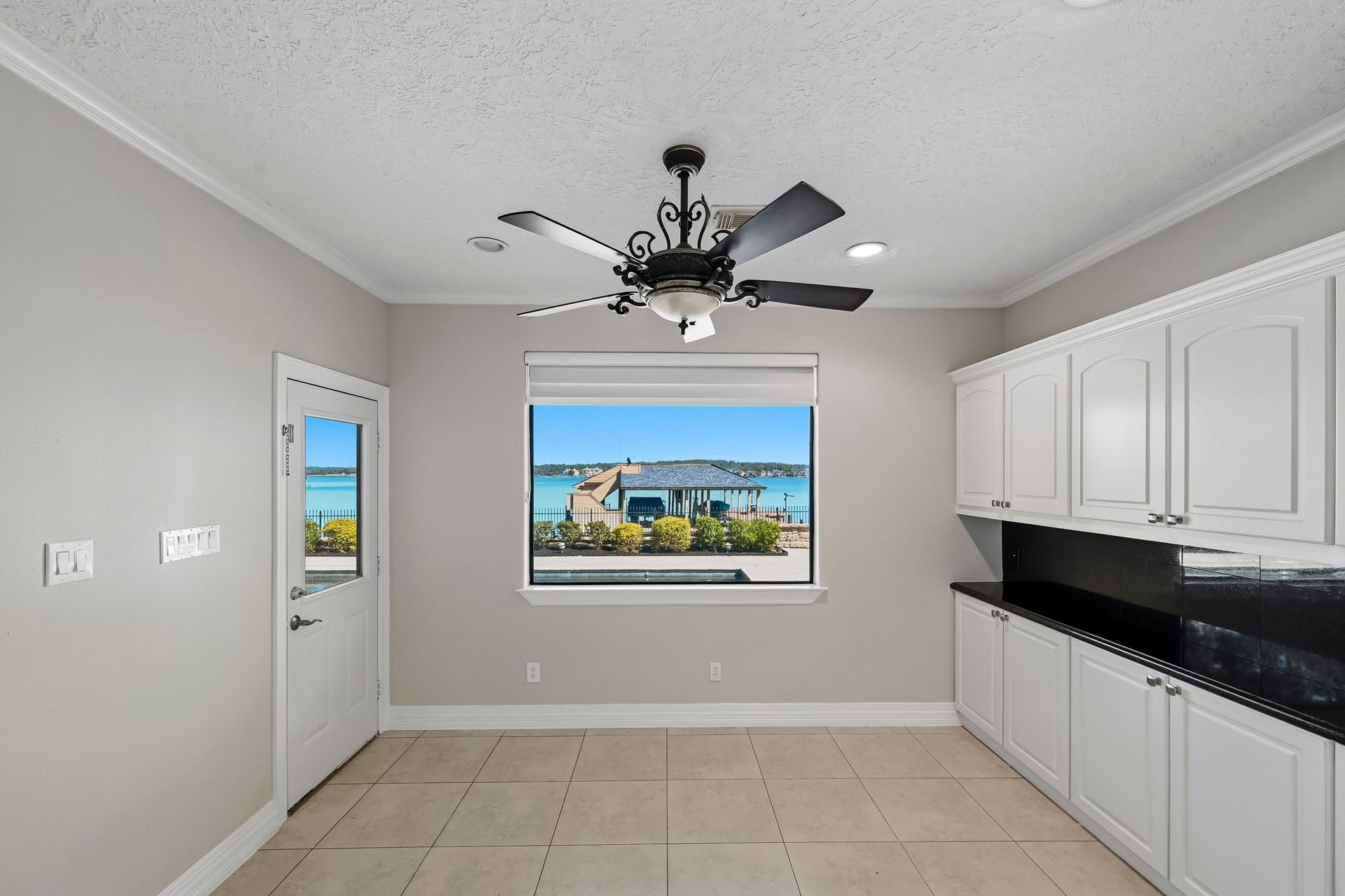 9354 Escondido Drive, Willis, TX 77318 Start your mornings with beautiful Lake Conroe views! This bright breakfast area offers additional storage cabinetry, pool and boathouse views and direct patio access.
