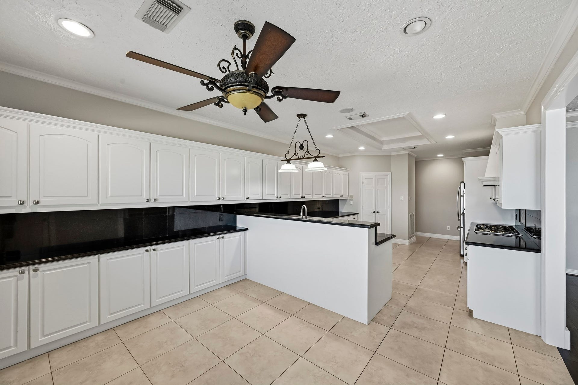 9354 Escondido Drive, Willis, TX 77318 Designed for functionality, the kitchen features expansive counter space, a prep sink, recessed lighting and attractive architectural ceiling details.