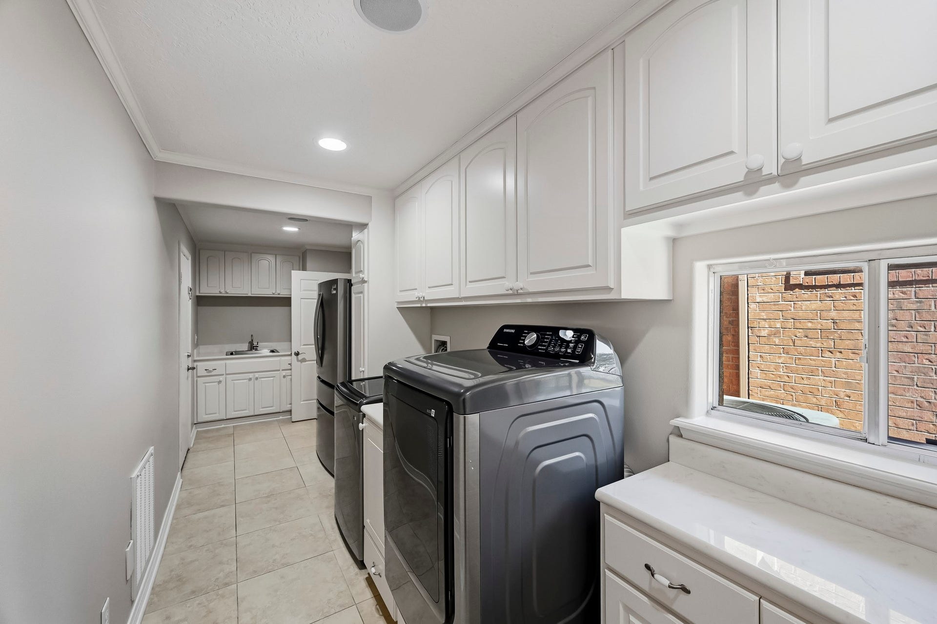 9354 Escondido Drive, Willis, TX 77318 This exceptional utility room offers extensive cabinetry, generous counter space, a utility sink and room for a second refrigerator. The washer, dryer, and refrigerator can stay!