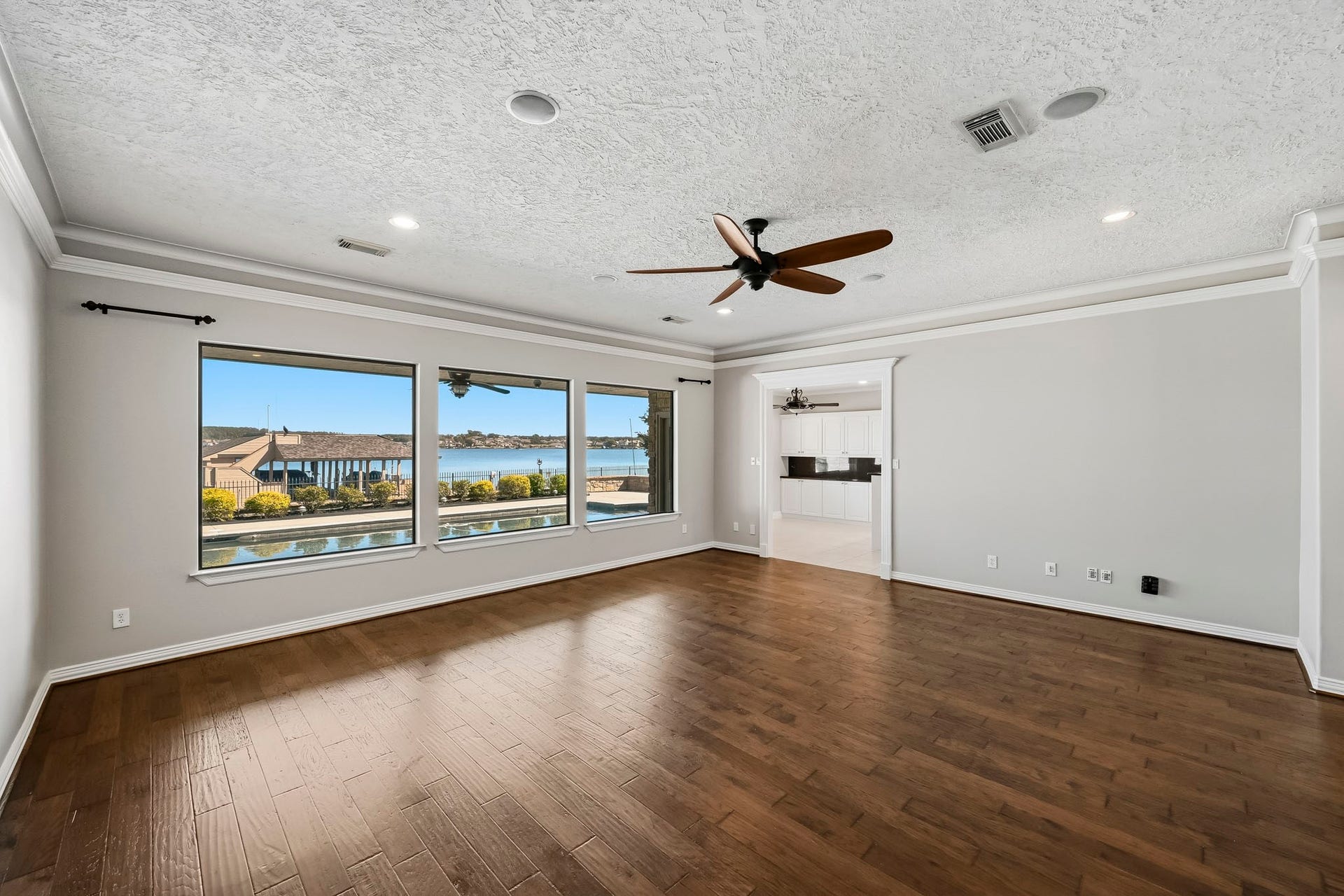 9354 Escondido Drive, Willis, TX 77318 WOW! Three oversized picture windows frame spectacular views of the sparkling pool and Lake Conroe, bringing waterfront beauty indoors!